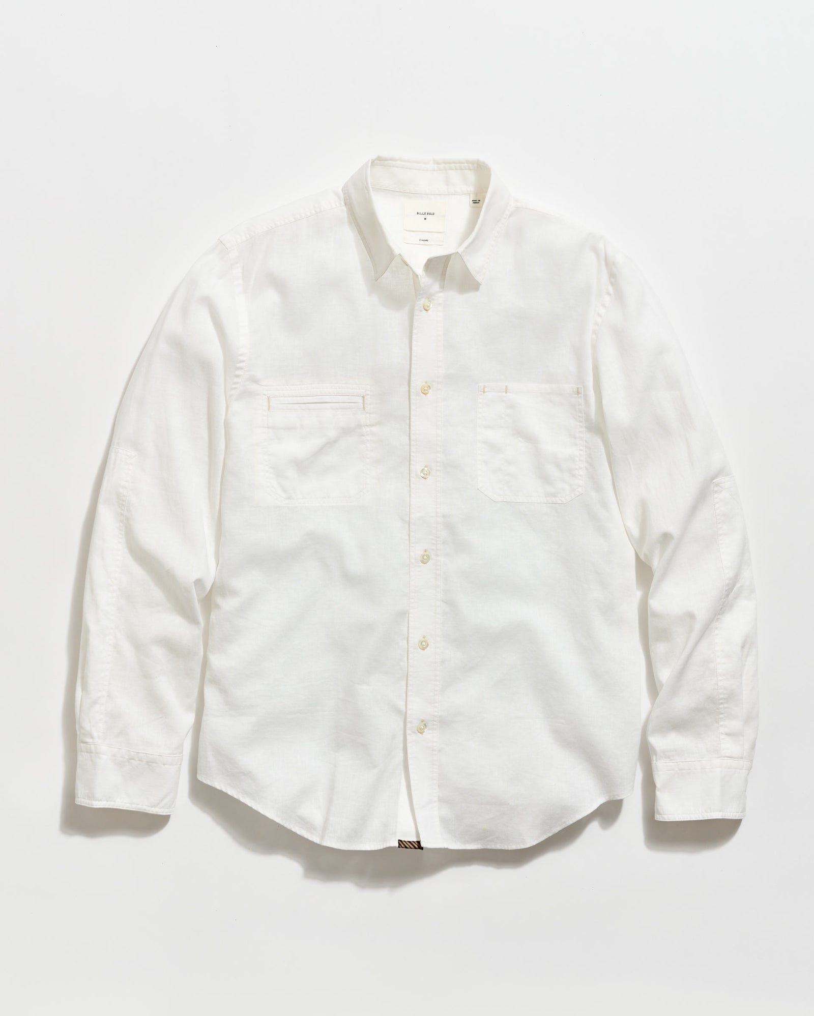 A long-sleeve, button-up white shirt with a collar and two chest pockets, laid flat on a plain white background.