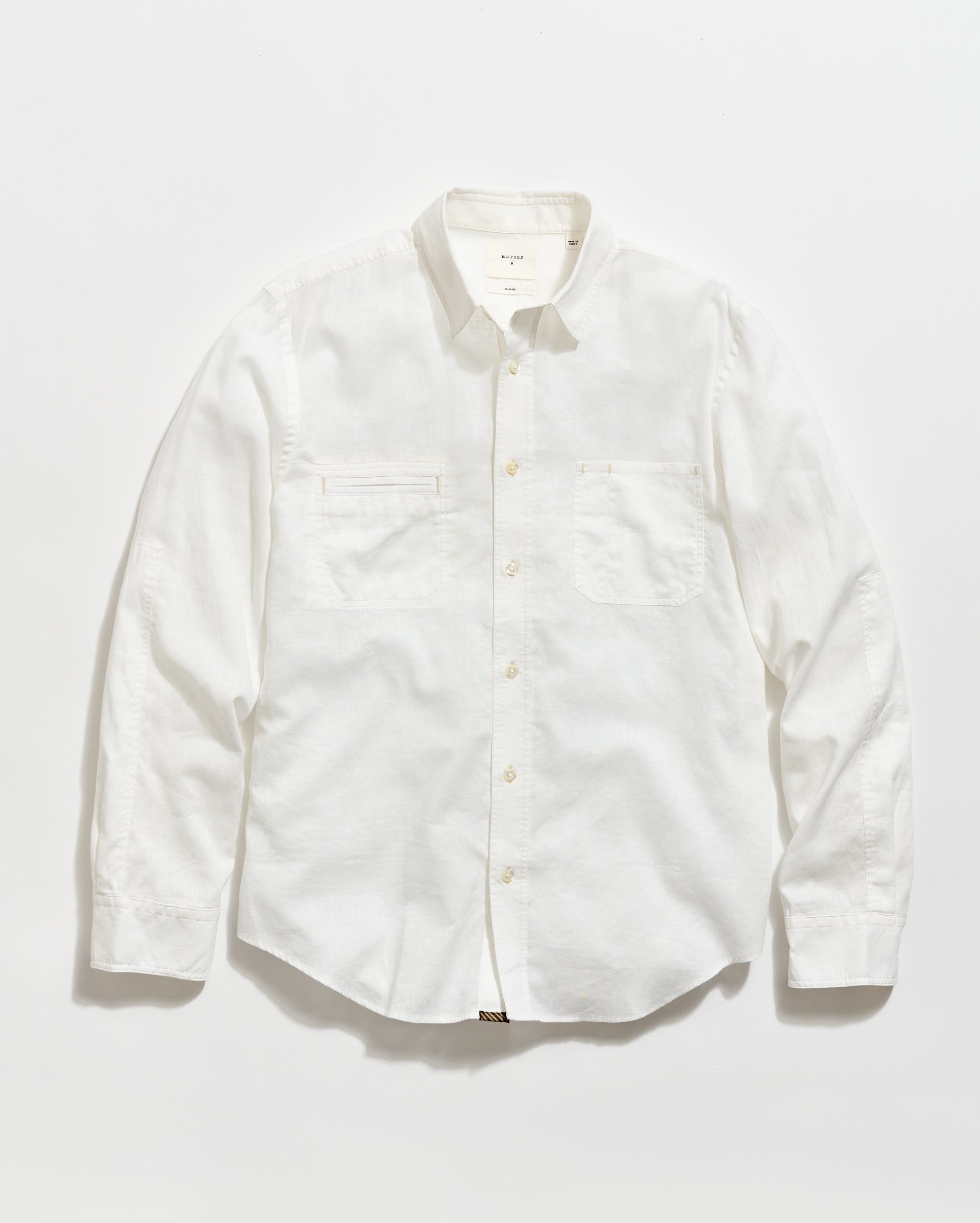 A long-sleeve, button-up white shirt with a collar and two chest pockets, laid flat on a plain white background.