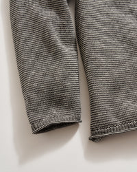 Close-up of a textured gray fabric on a light beige background