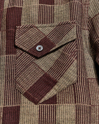 Close-up of a brown and beige plaid fabric with a button pocket detail
