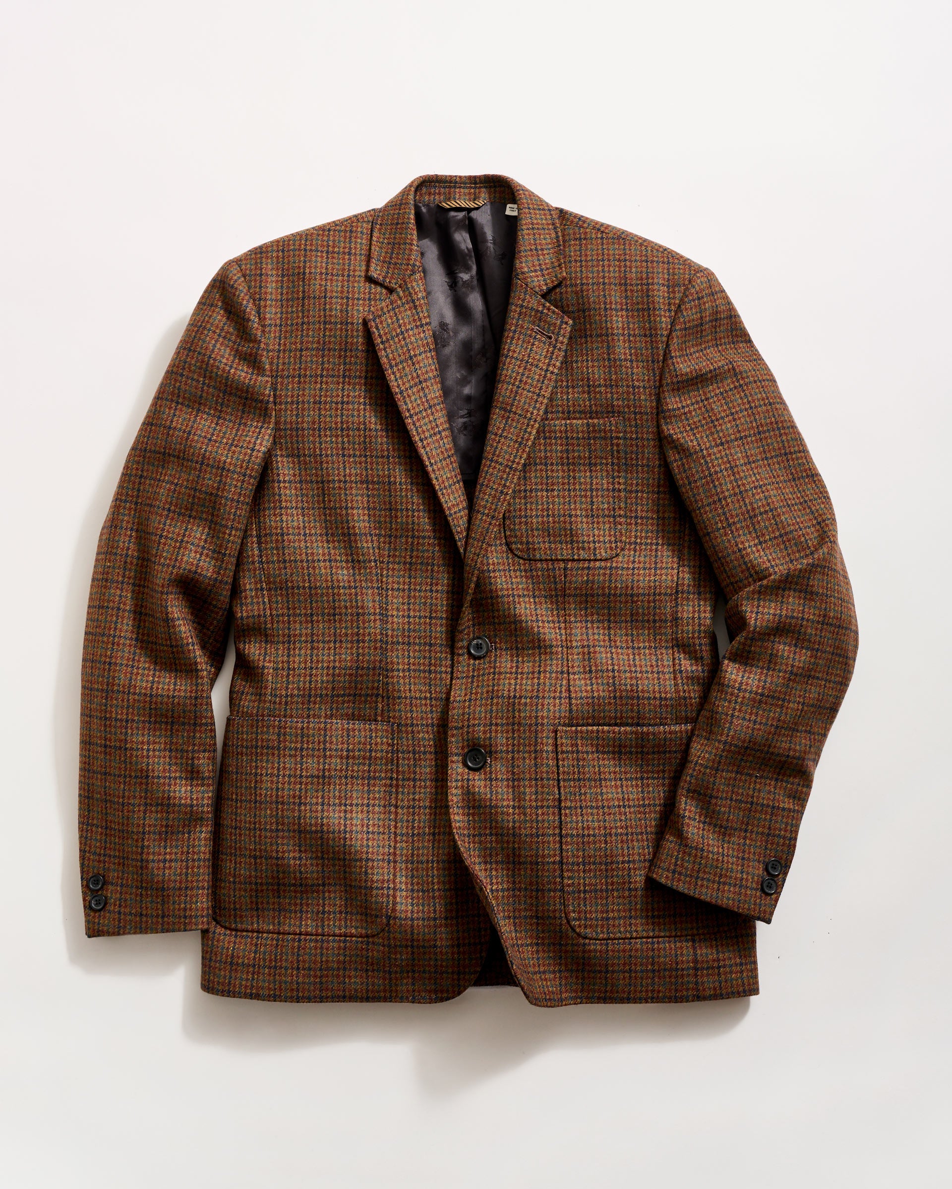 A brown plaid blazer with a notched lapel, two buttons, and three front pockets, laid flat on a white background.