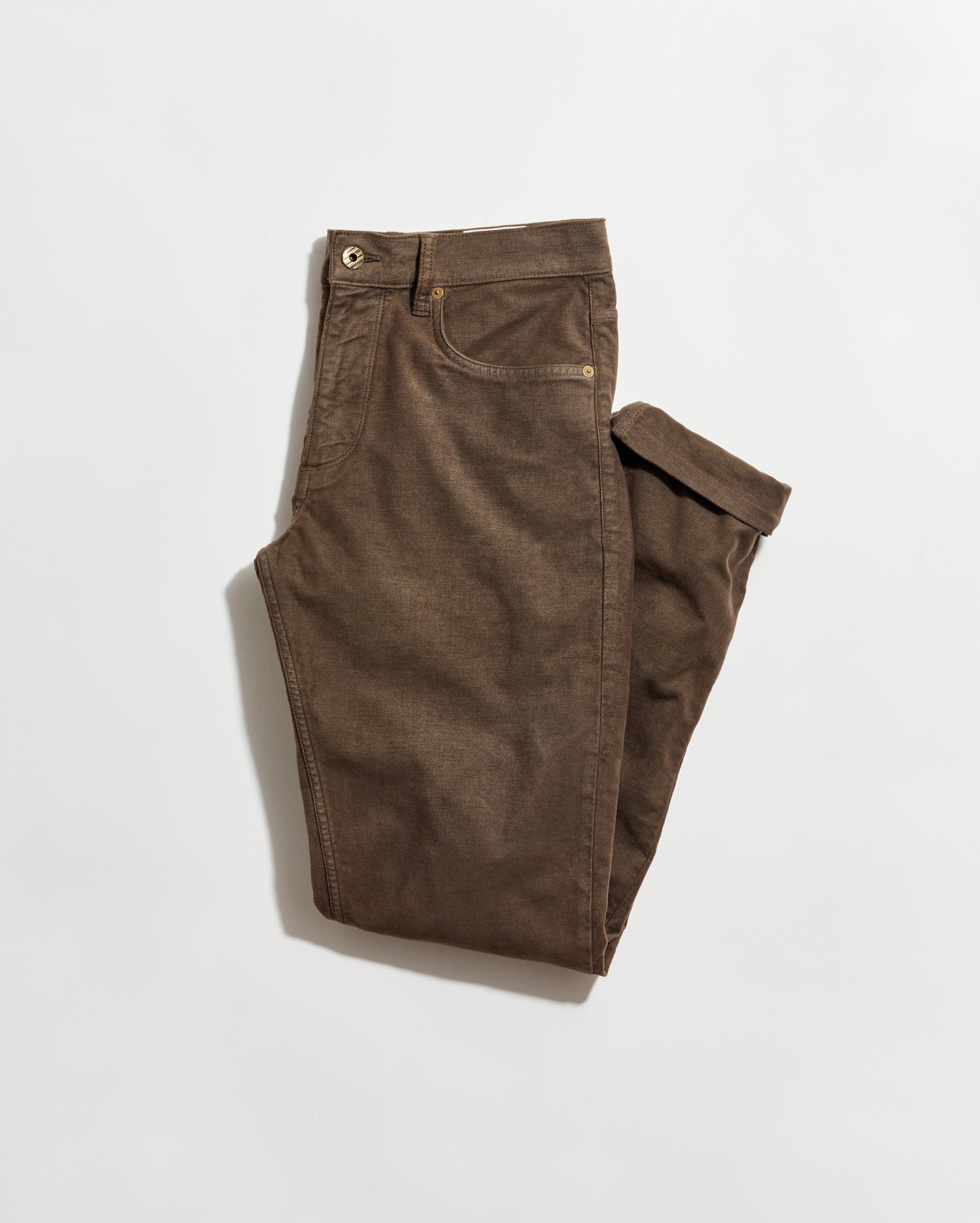 A pair of brown pants neatly folded on a plain white background. The pants have front and back pockets, belt loops, and a button closure at the waist.