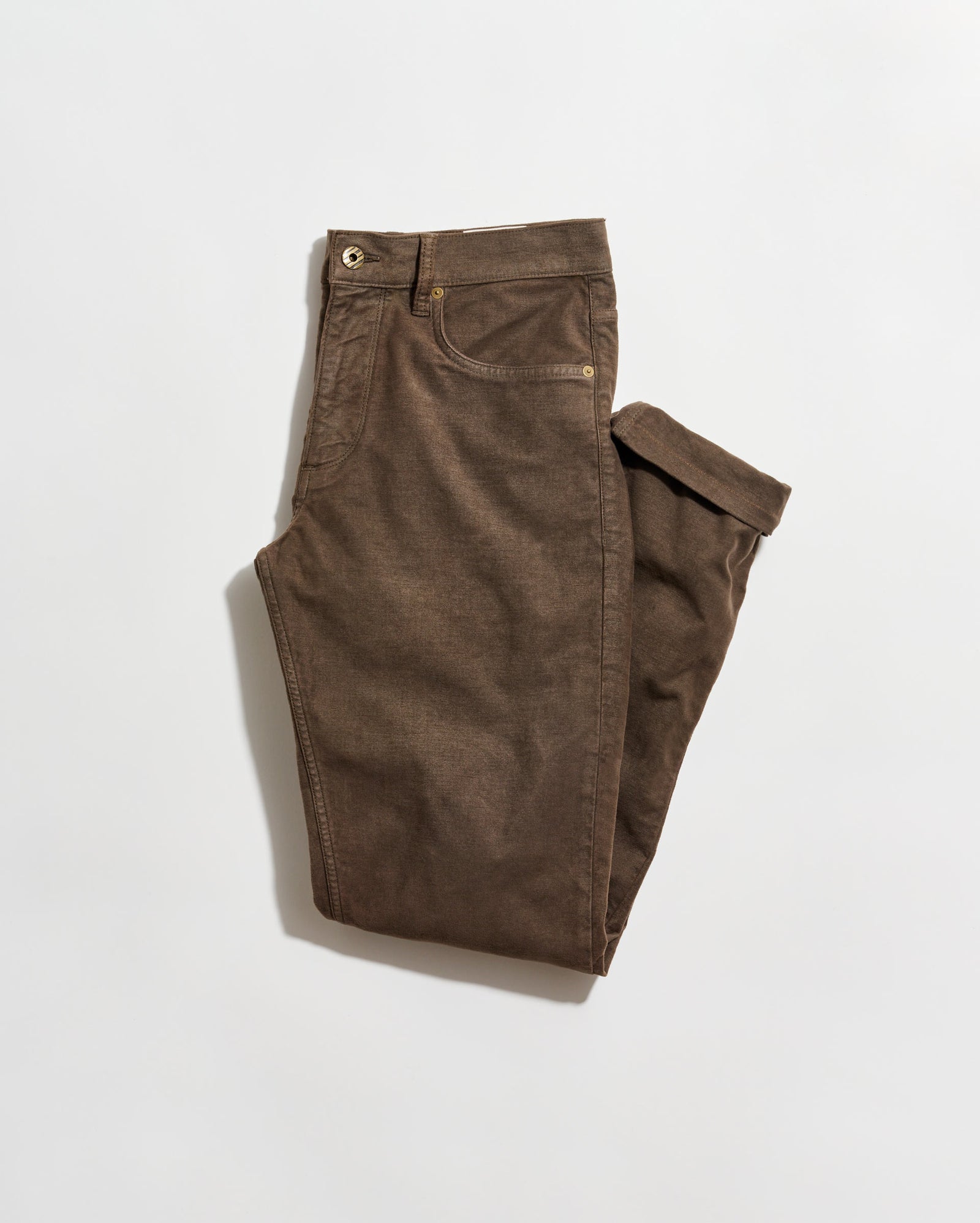 A pair of brown pants neatly folded on a plain white background. The pants have front and back pockets, belt loops, and a button closure at the waist.