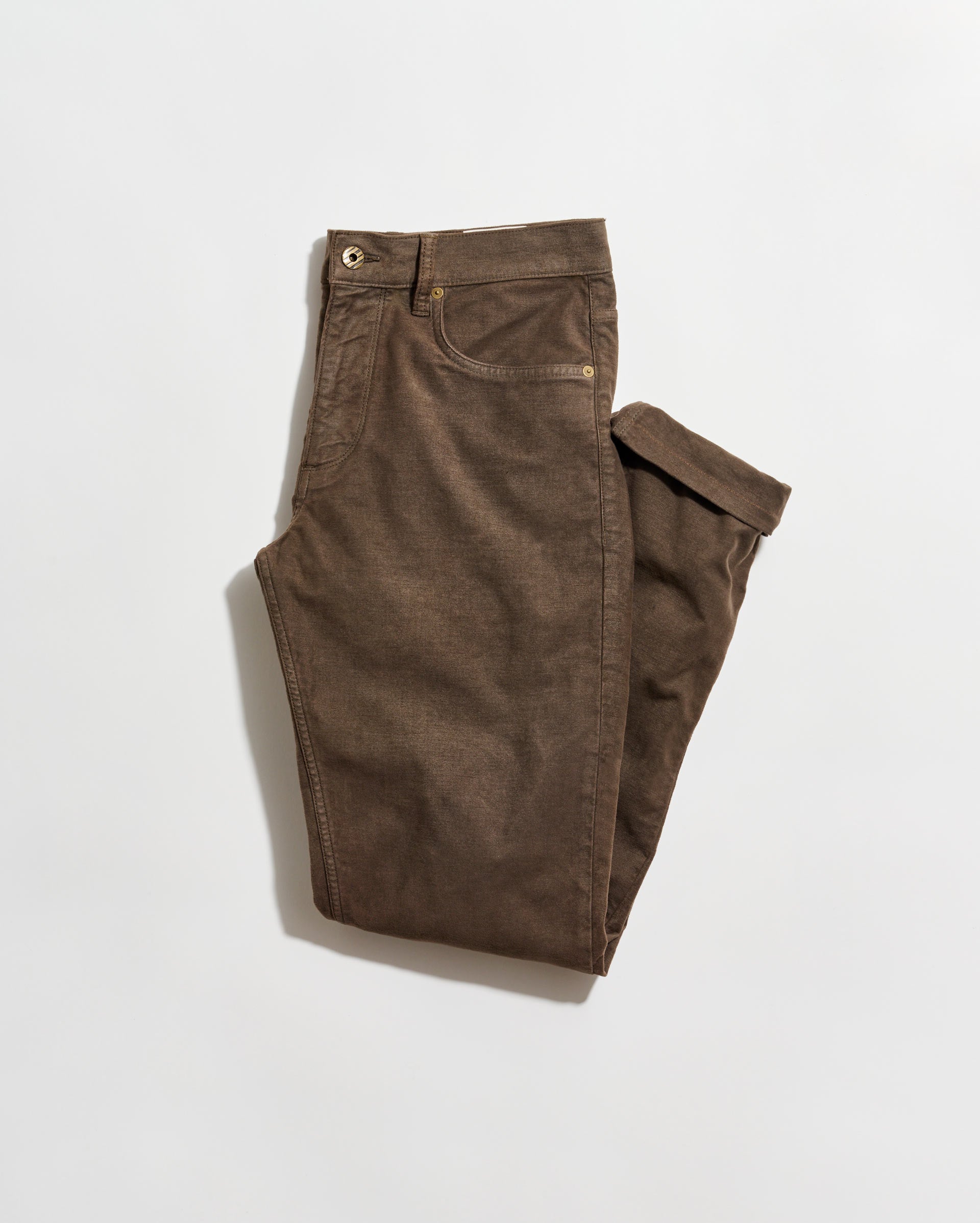 A pair of brown pants neatly folded on a plain white background. The pants have front and back pockets, belt loops, and a button closure at the waist.