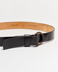 A dark brown leather belt with a round brass buckle, partially buckled, against a plain white background. The inside of the belt is tan and stamped with “BILLY REID” and sizing information.