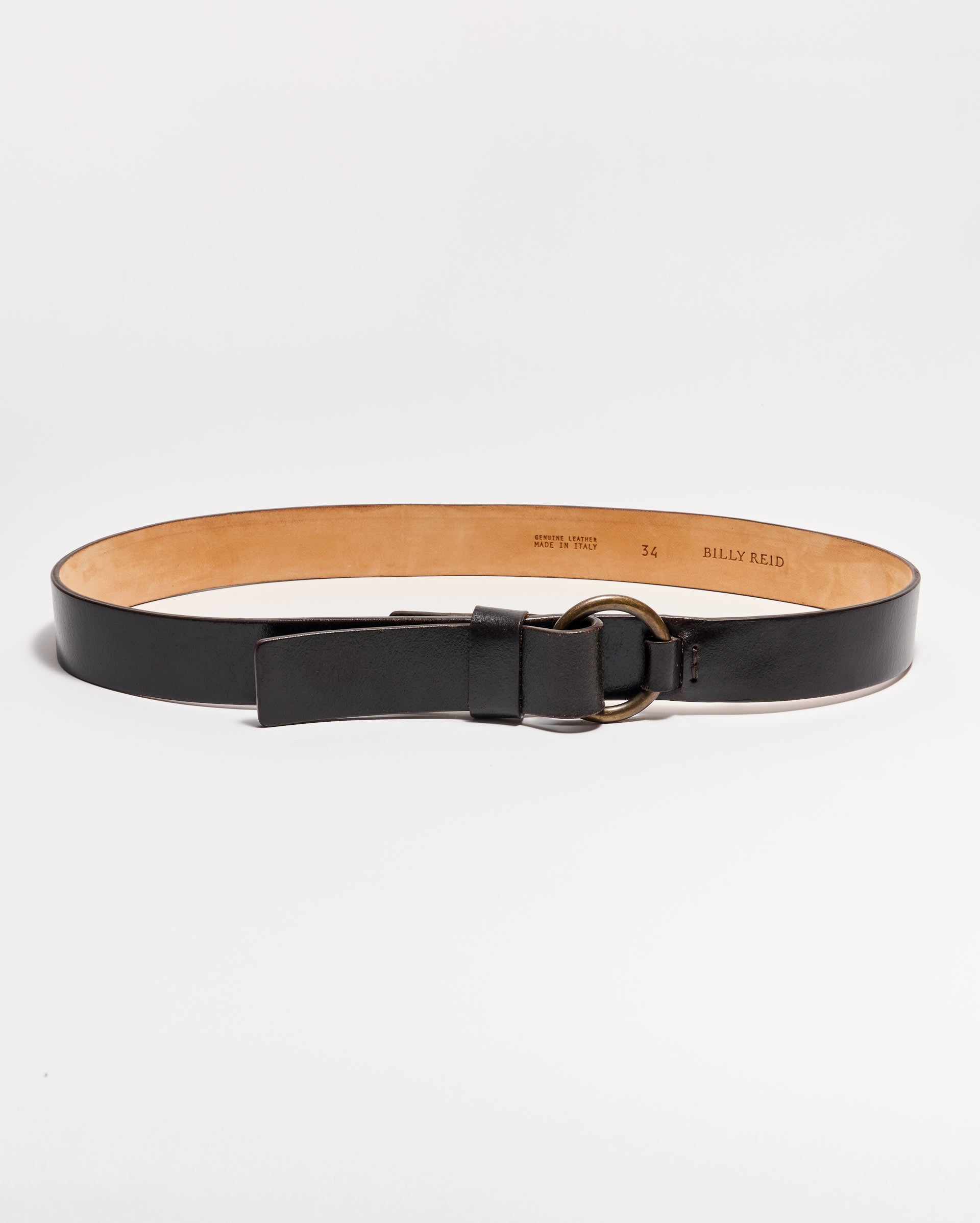 A black leather belt with a tan interior, featuring a round metal buckle and a single loop, displayed on a white background.