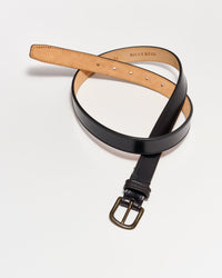 A black leather belt with a brass buckle is coiled on a white surface. The inner side of the belt is tan and has the brand name BILLY REID and the size 34 stamped on it.