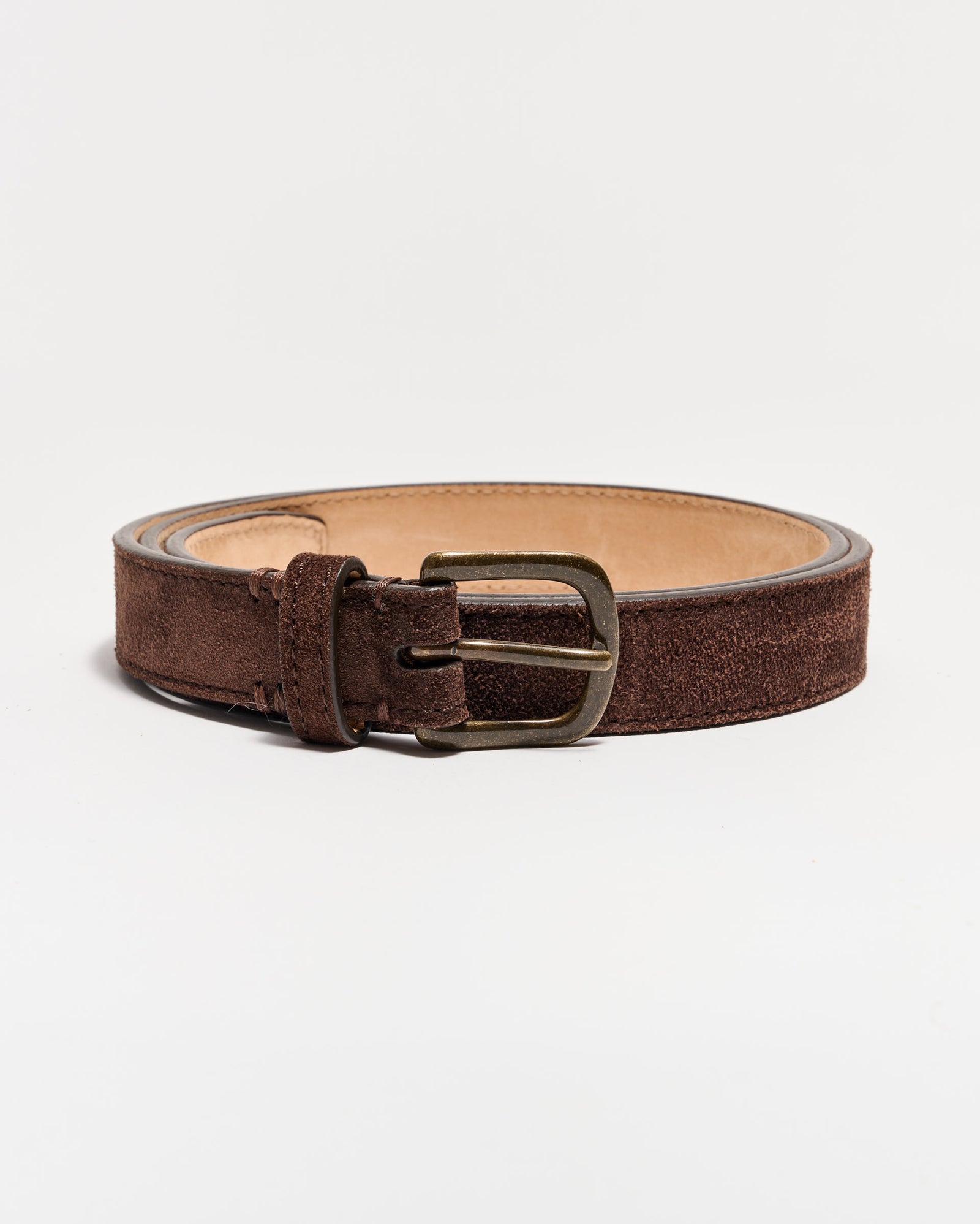 A brown suede leather belt with a metal buckle, coiled on a plain white background.