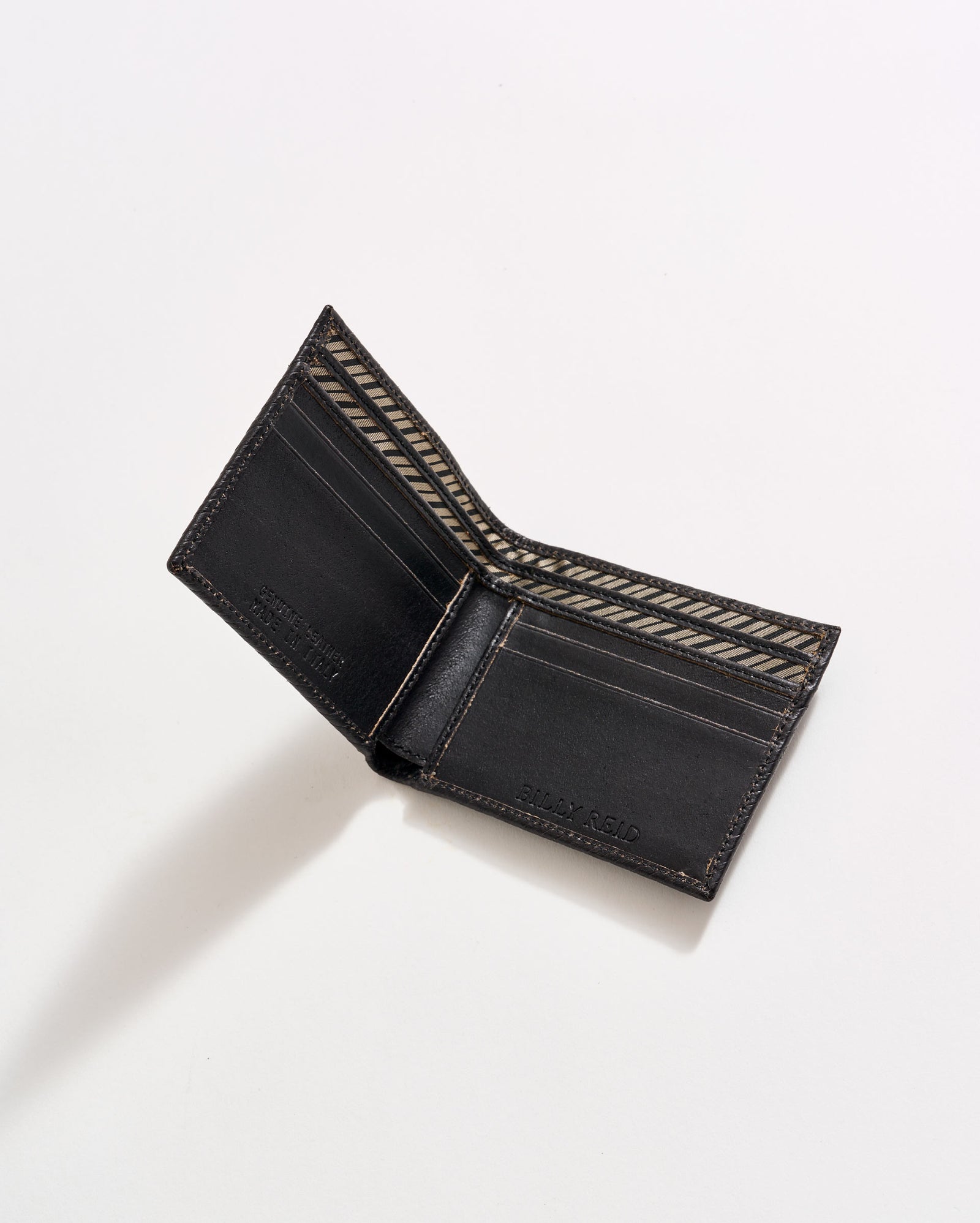 An open black leather wallet with brown stitching, showing multiple card slots and a patterned interior, photographed on a white background.