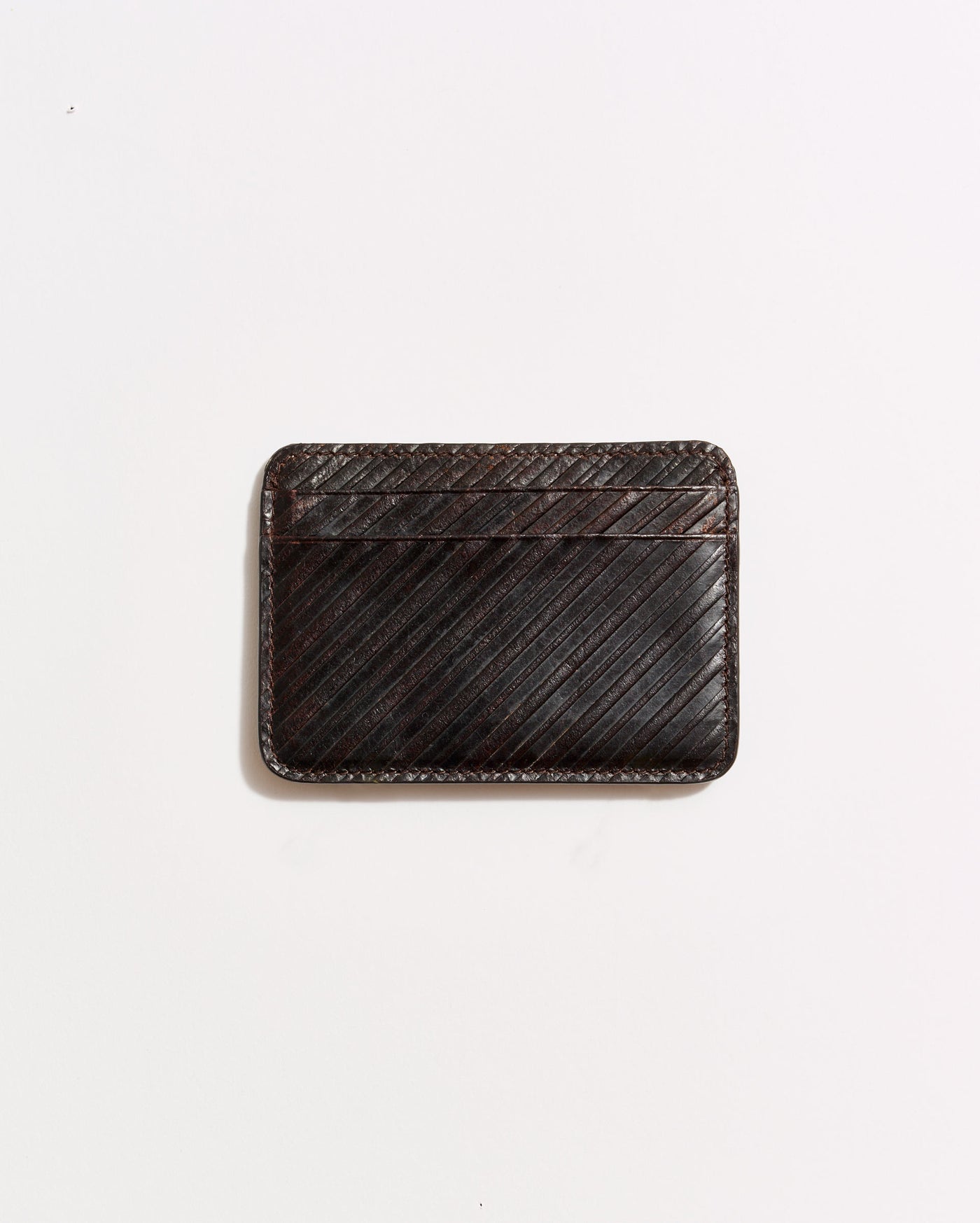 A dark brown leather cardholder with diagonal stitching, placed on a plain white background.