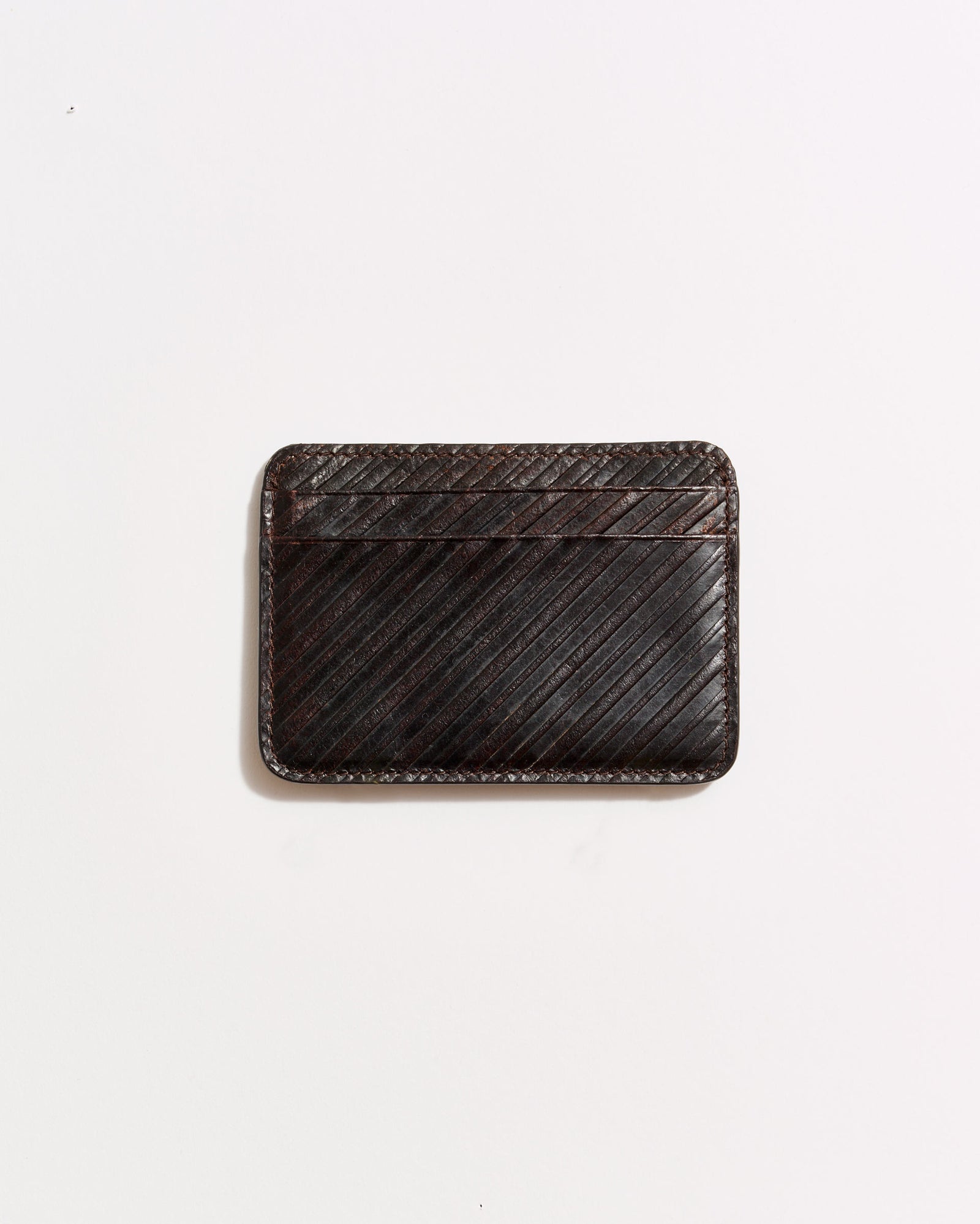 A dark brown leather cardholder with diagonal stitching, placed on a plain white background.