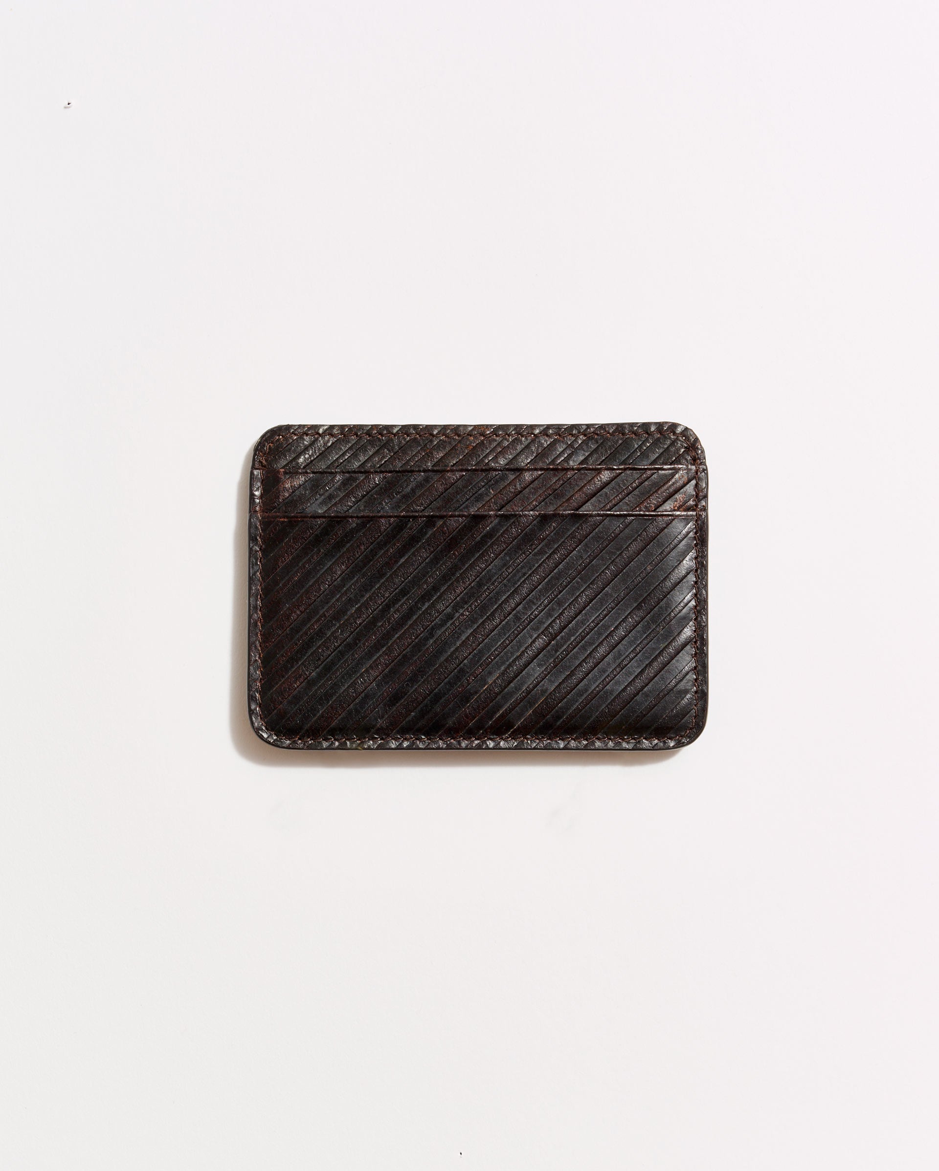 A dark brown leather cardholder with diagonal stitching, placed on a plain white background.