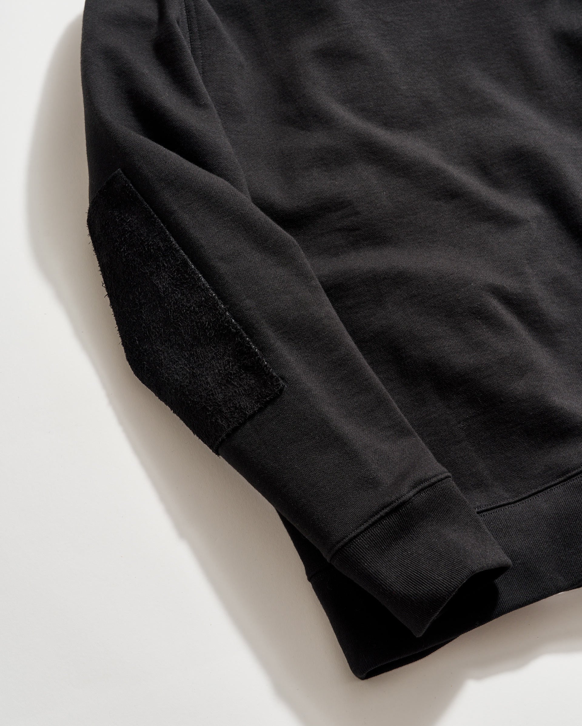 Black sweatshirt on a light beige background