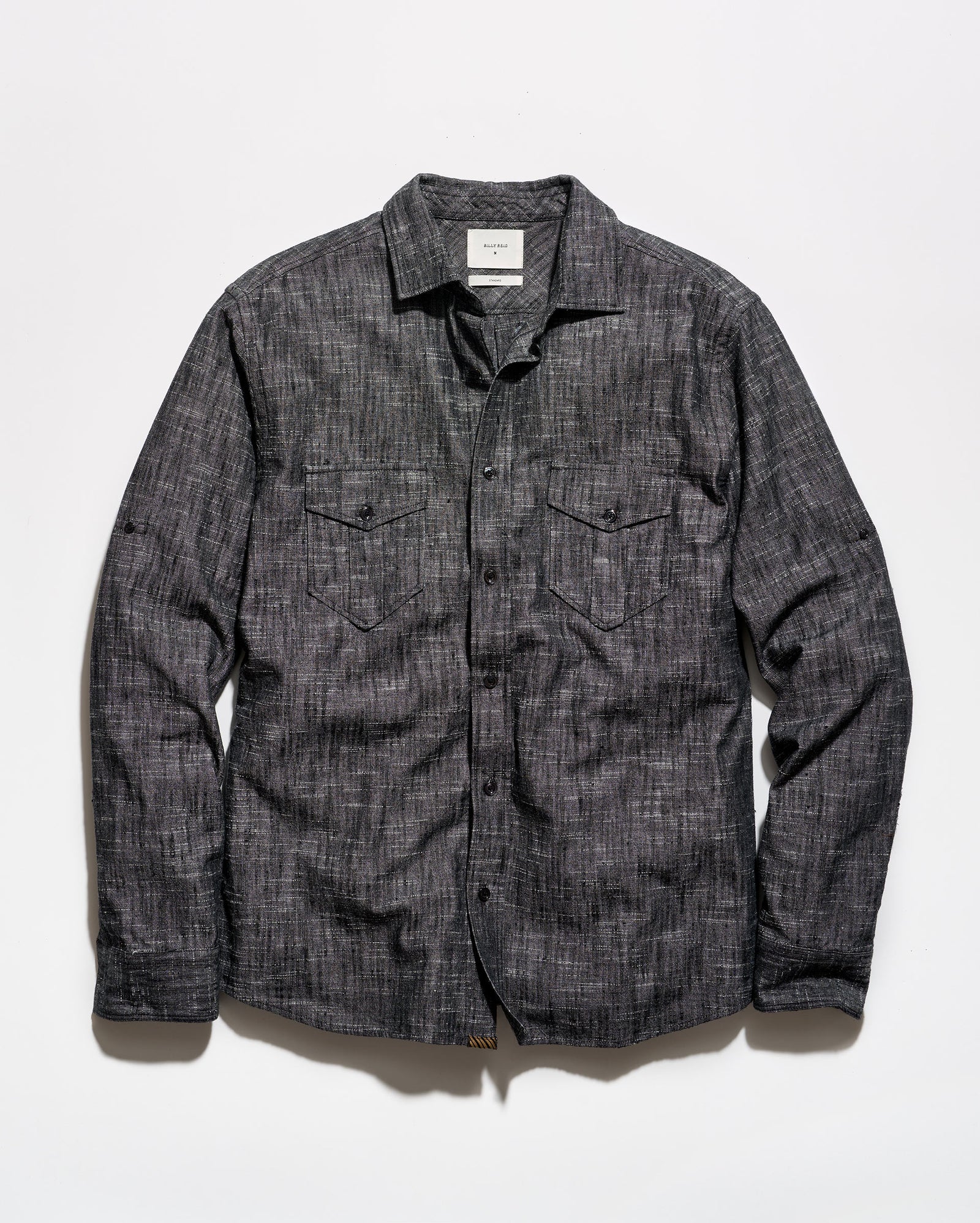 A dark gray textured long-sleeve button-up shirt with two chest flap pockets, laid flat against a white background.