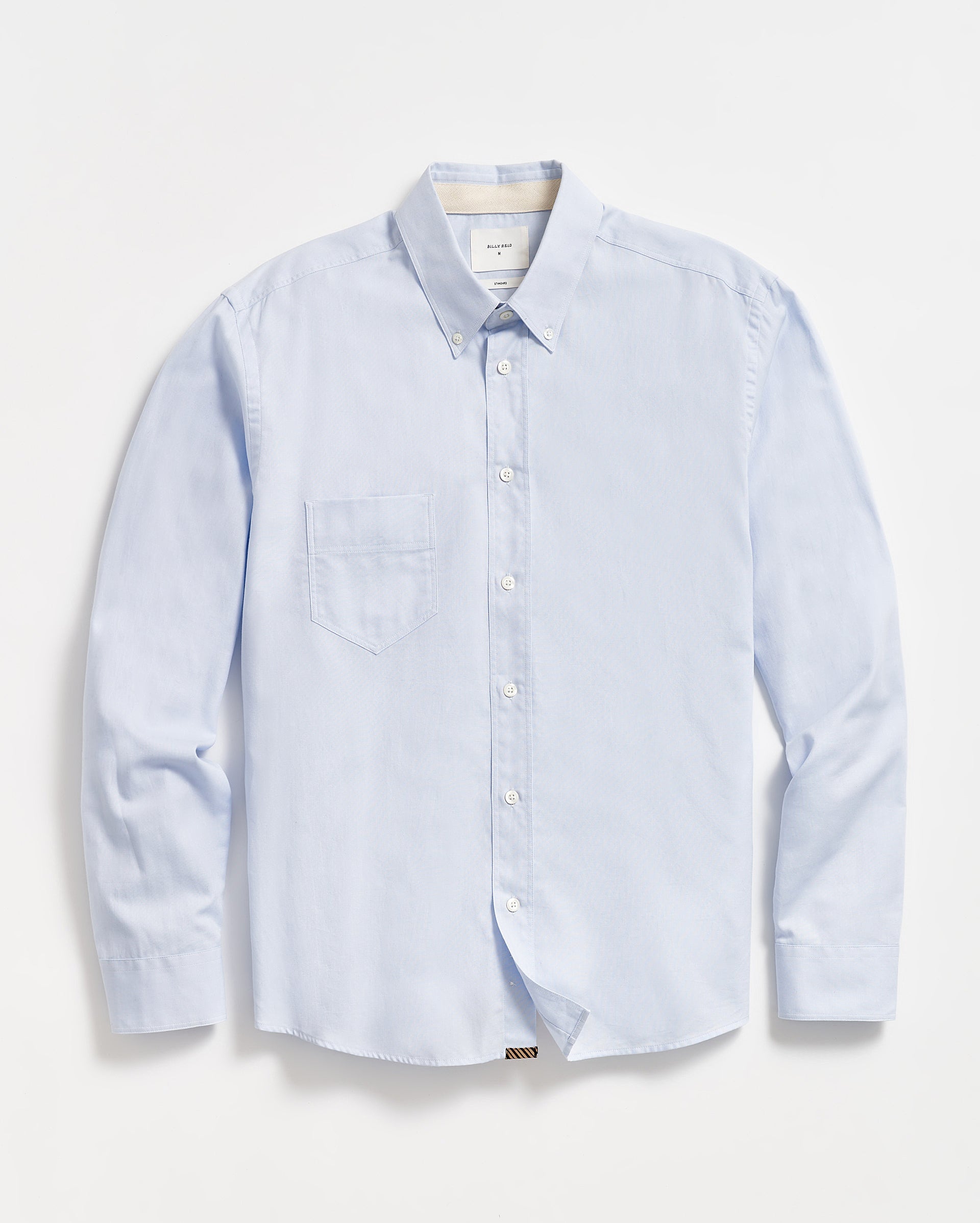 A light blue, long-sleeve button-down shirt with a single chest pocket, buttoned collar, and white buttons, laid flat on a white background.