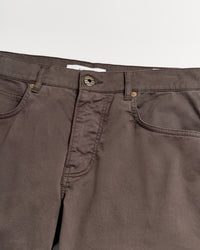 A close-up view of the waistband and upper section of brown pants with visible pockets, belt loops, and a button closure against a white background.