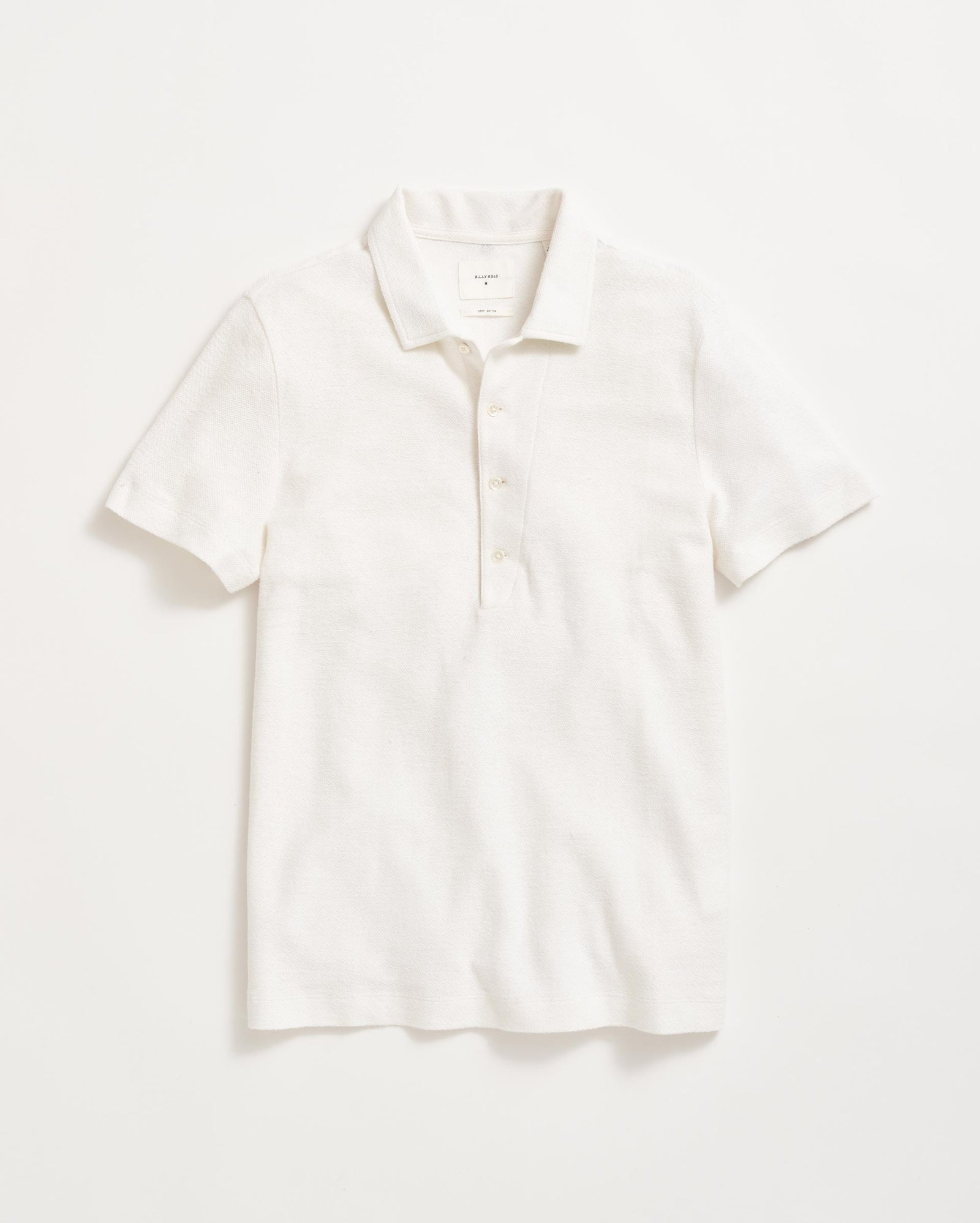 A plain white short-sleeve polo shirt with a collar and three buttons, laid flat on a white background.
