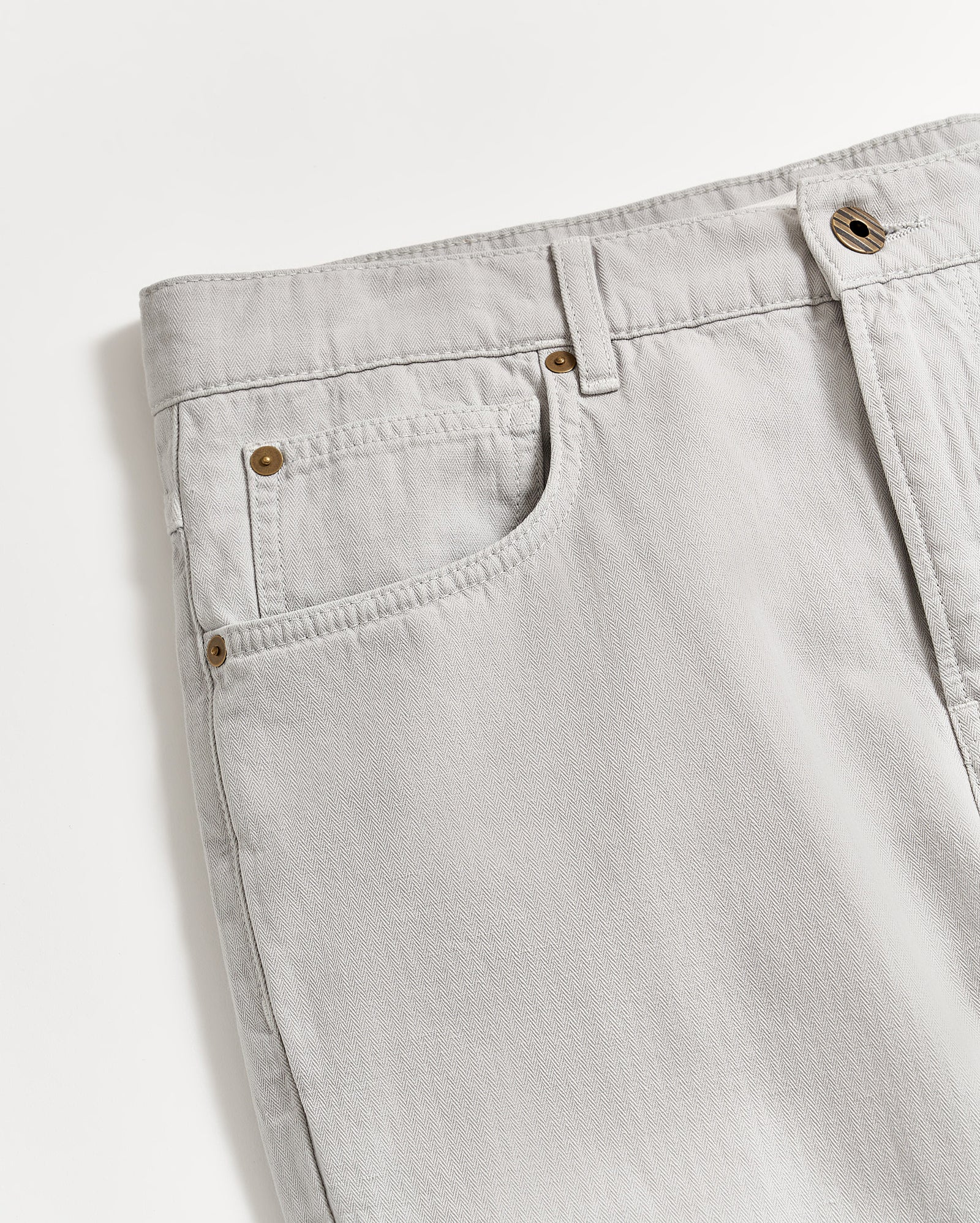 Light gray denim jeans shown from the waist down to mid-thigh, featuring front pockets, belt loops, and a metal button closure, photographed on a white background.