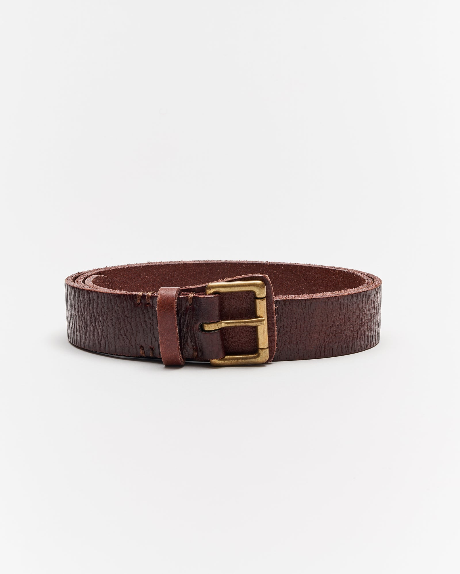 A coiled brown leather belt with a brass buckle, displayed against a plain white background.