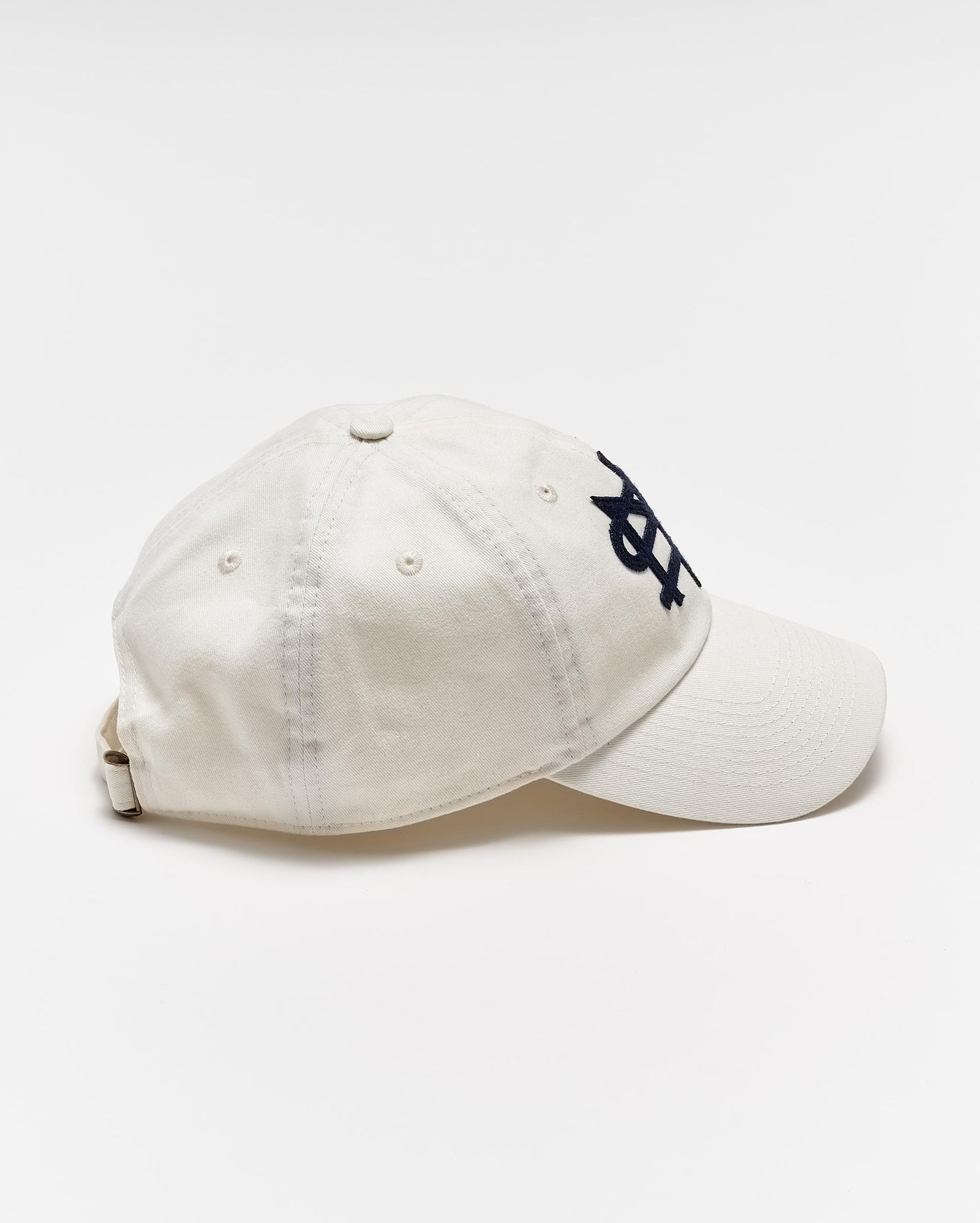 A white baseball cap with a curved brim, featuring a black embroidered overlapping NY logo on the front, is photographed on a plain white background.