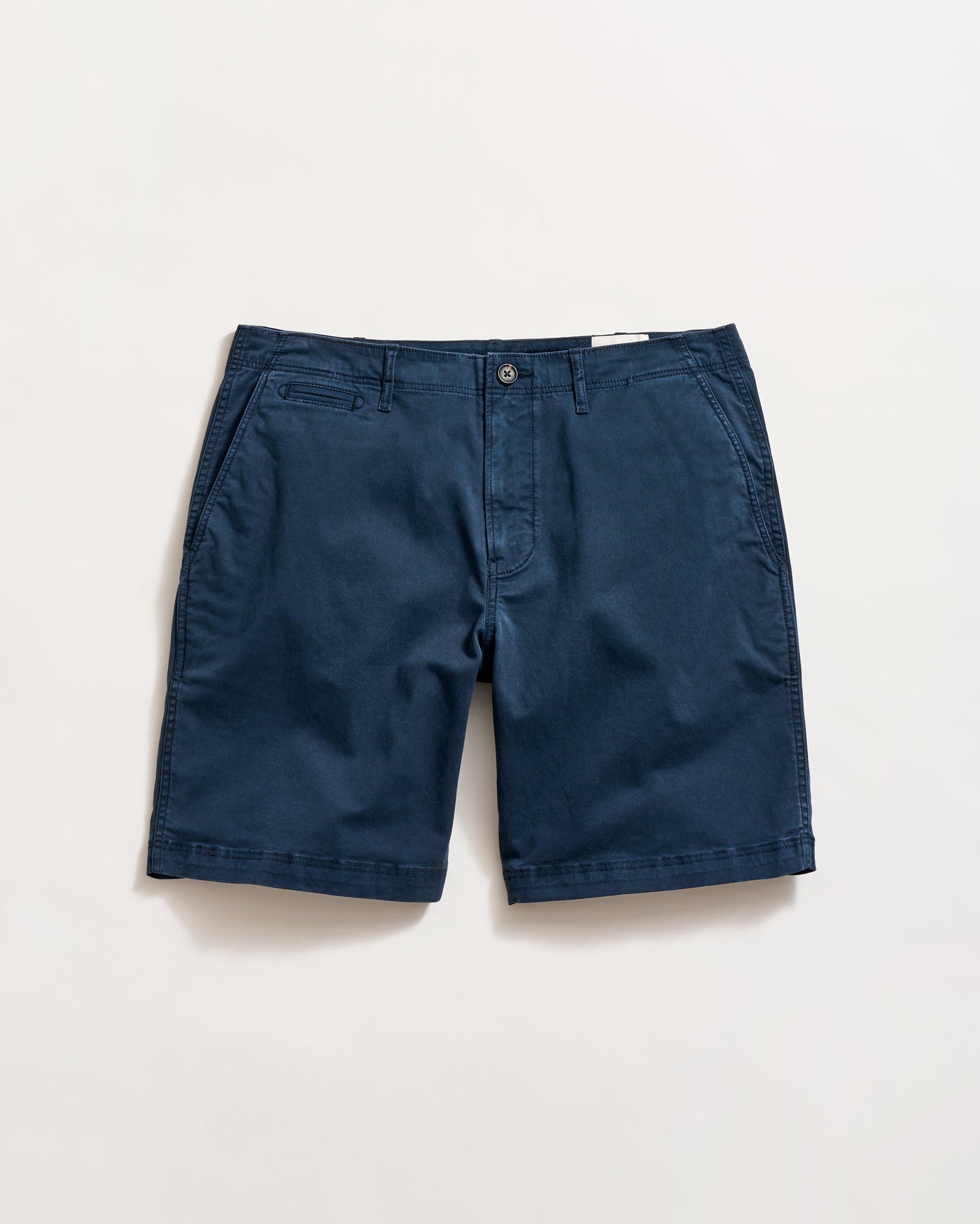 A pair of navy blue chino shorts with side pockets, a small coin pocket on the right, and a button closure, laid flat on a white background.