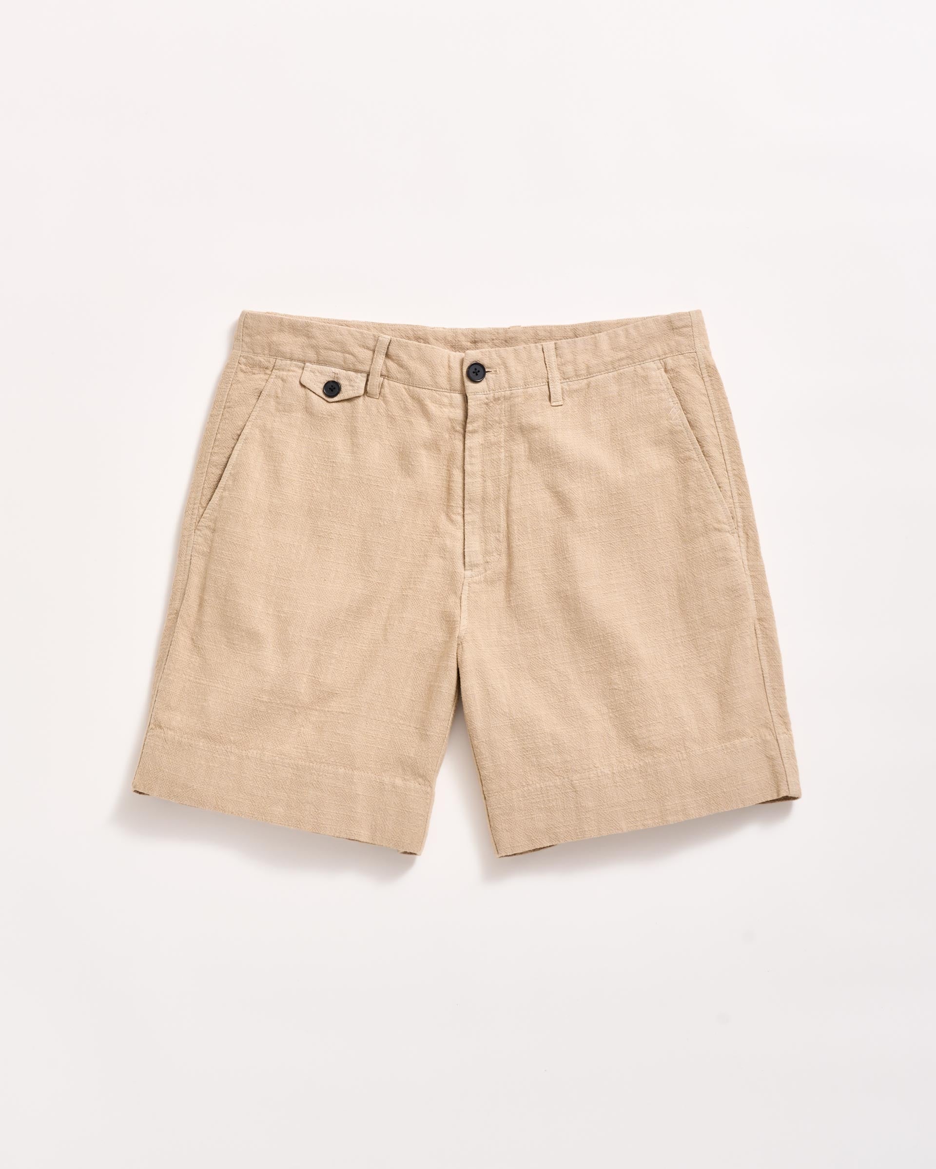 A pair of beige linen shorts with side pockets, belt loops, and a front button and zipper closure, displayed flat on a white background.