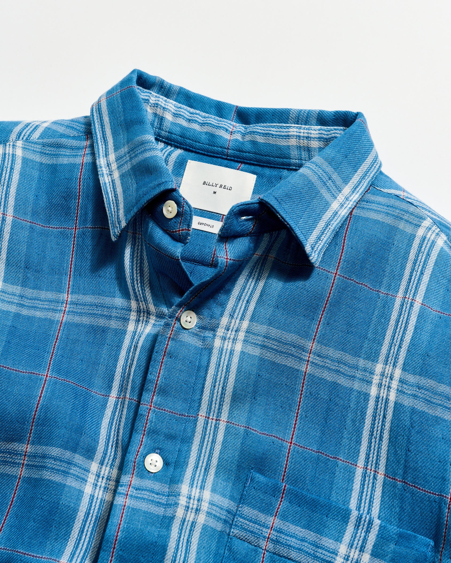 Blue plaid shirt with collar and buttons on a white background