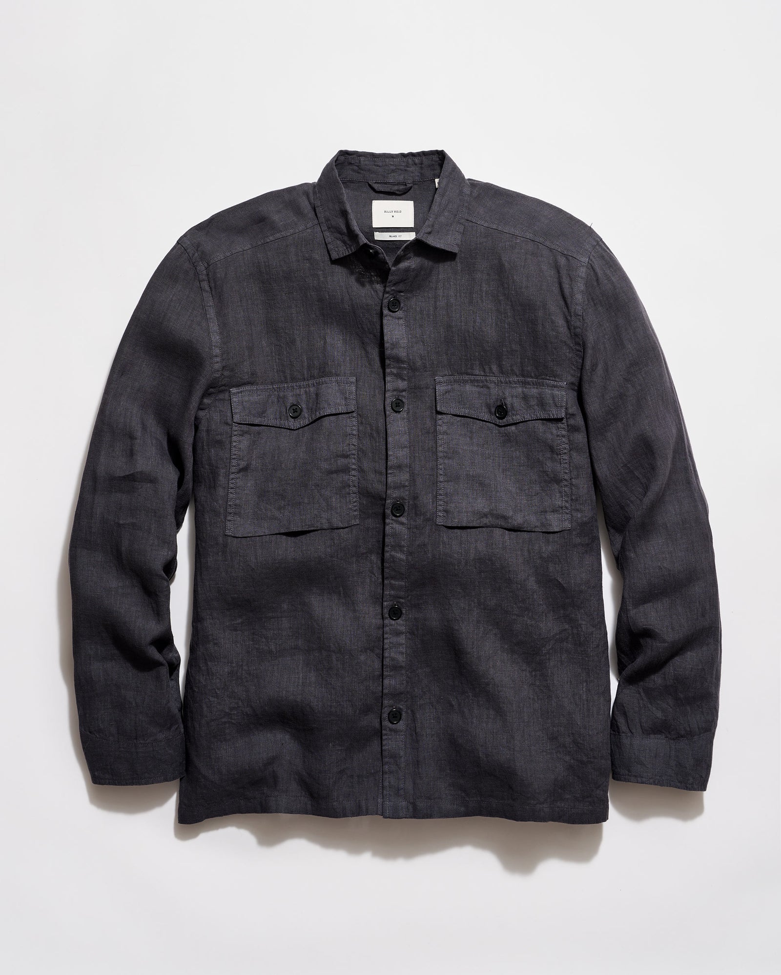 Dark denim shirt with two front pockets on a light gray background