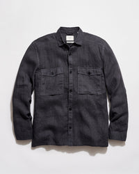 Dark denim shirt with two front pockets on a light gray background