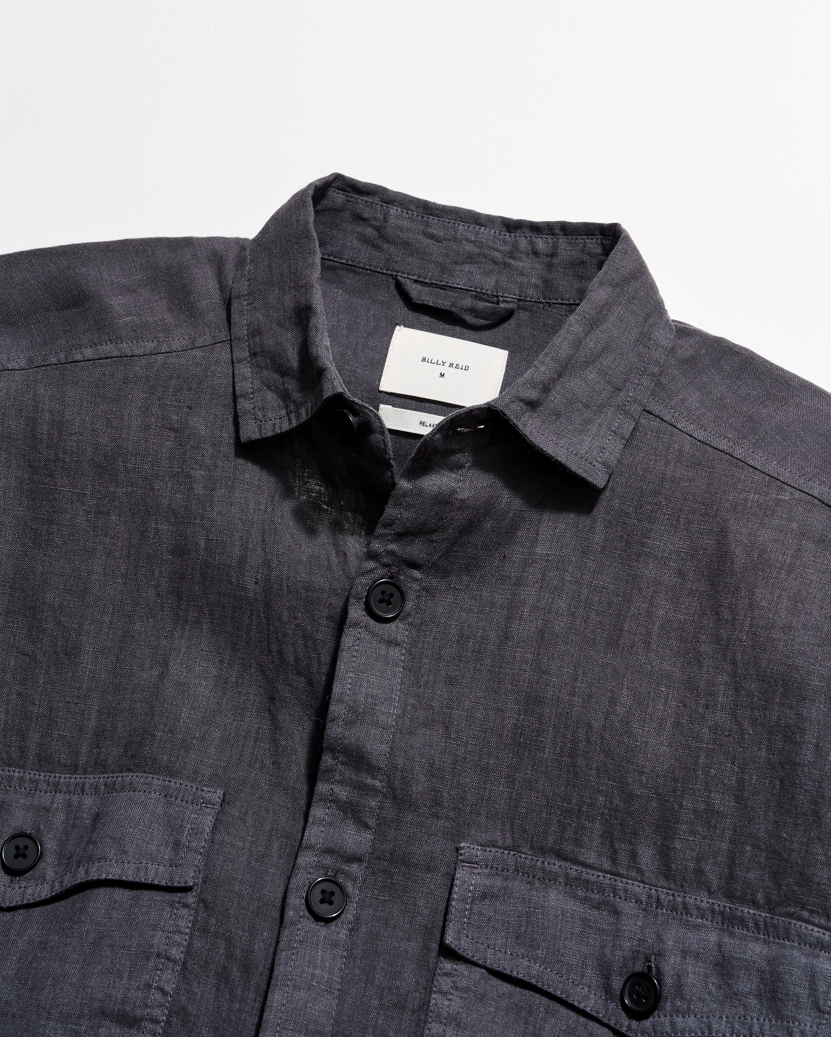 Dark gray shirt with collar and buttons on a light gray background