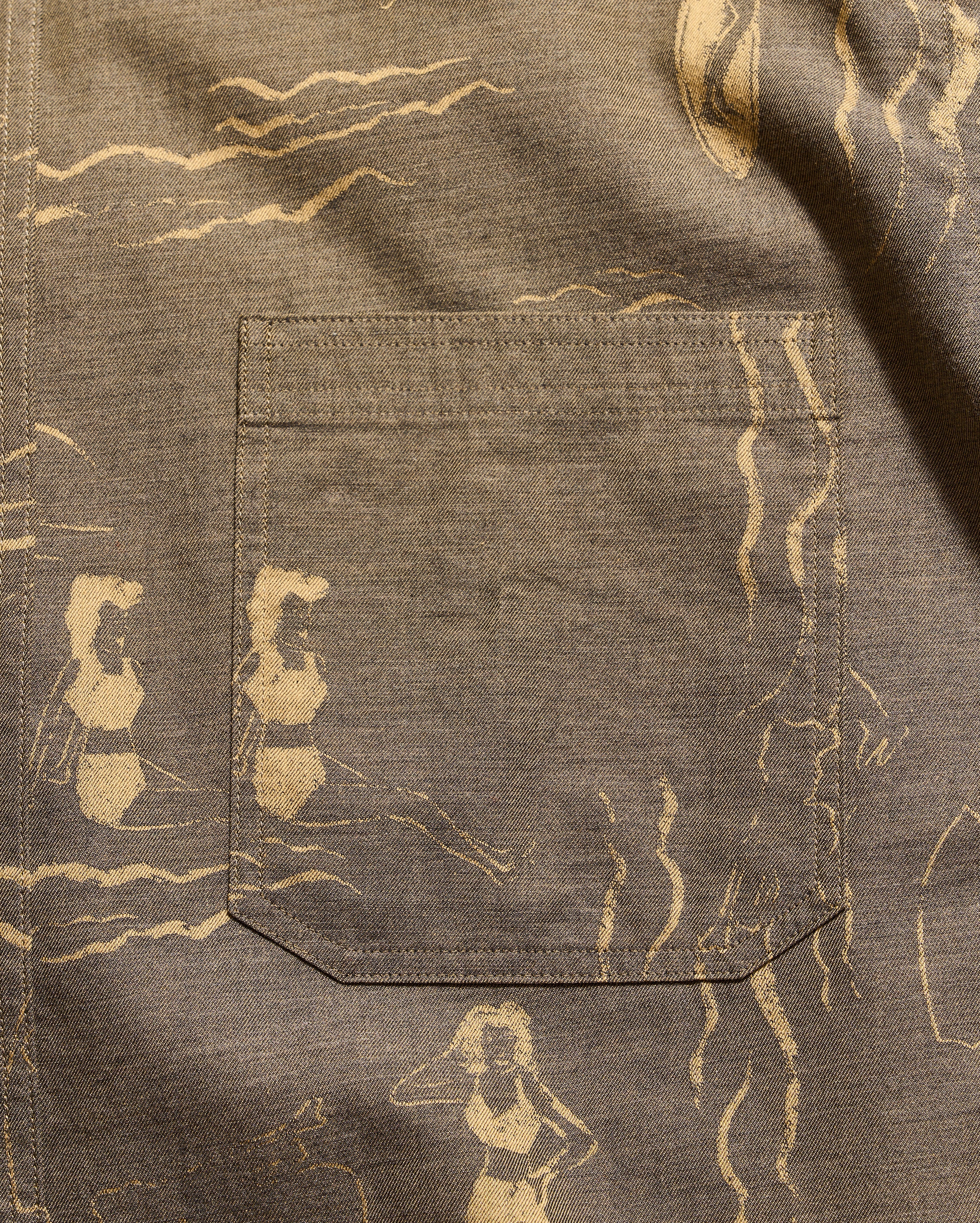 Brown fabric with beige abstract patterns and a pocket.
