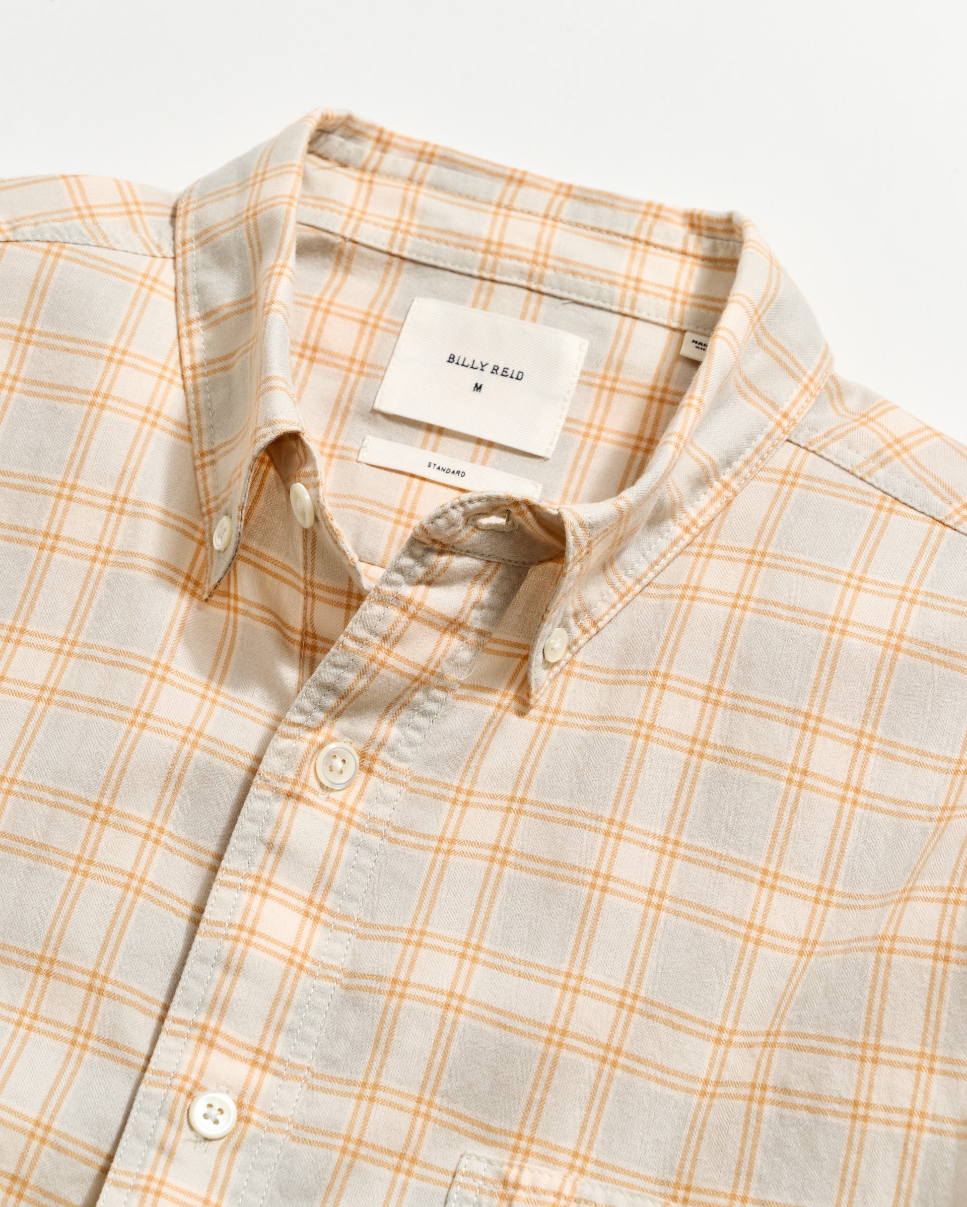 Plaid shirt with a visible brand tag on a light background