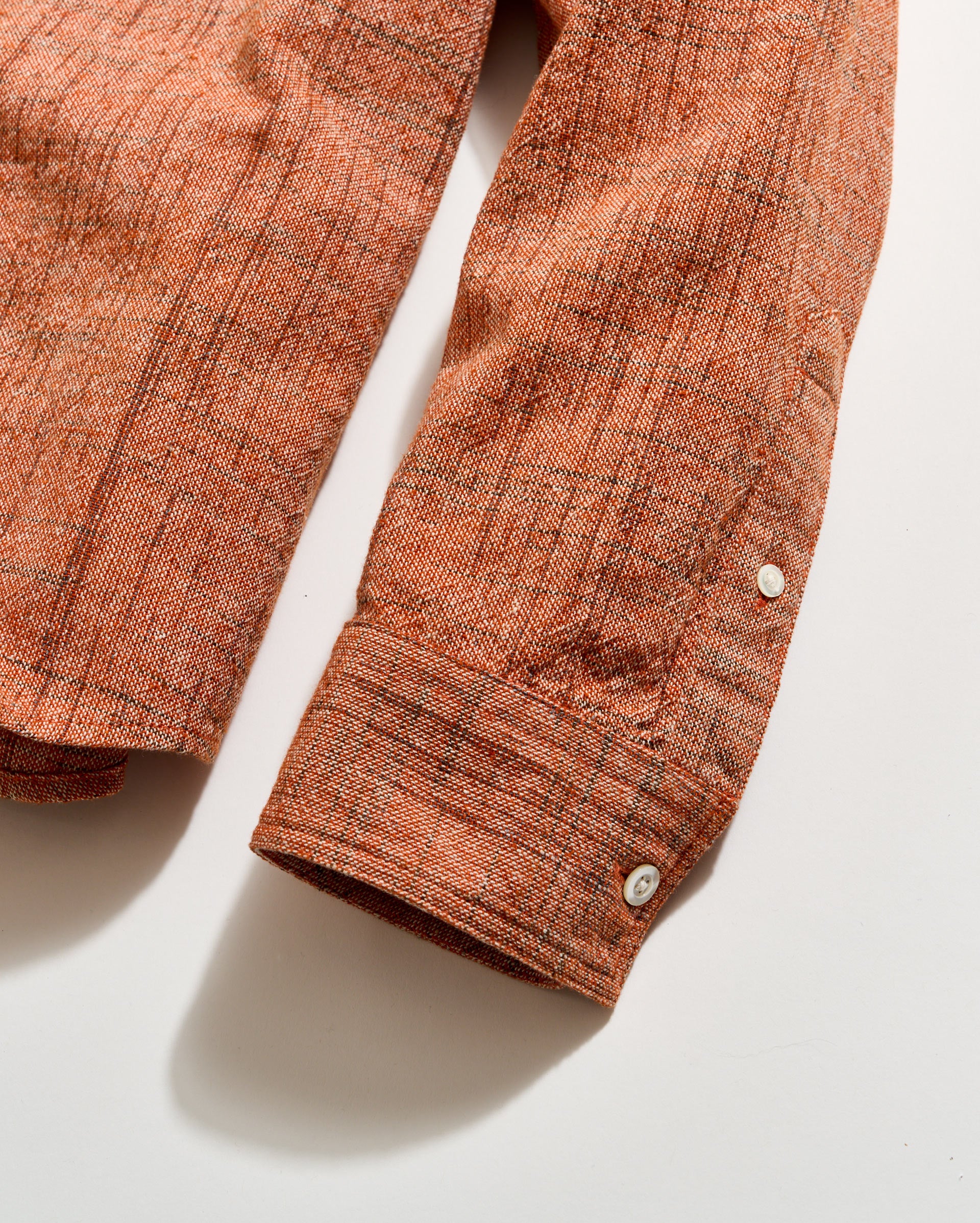 Close-up of a brown textured shirt sleeve on a light background