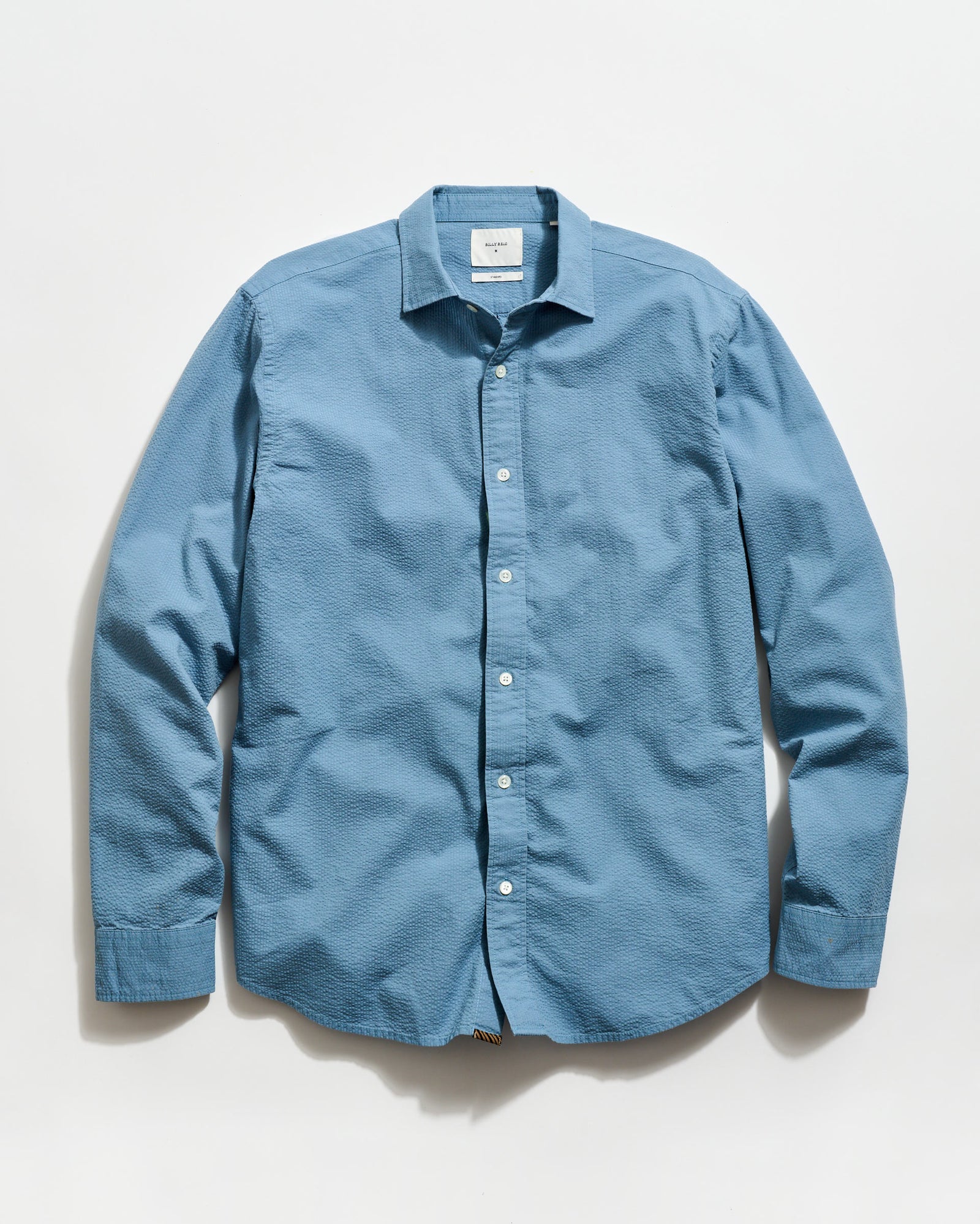 Blue button-up shirt on a light gray background