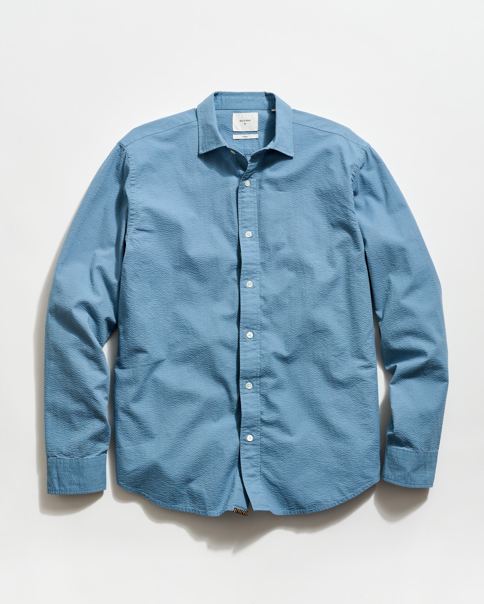 Blue button-up shirt on a light gray background