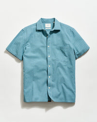 Blue patterned short-sleeve shirt on a light gray background