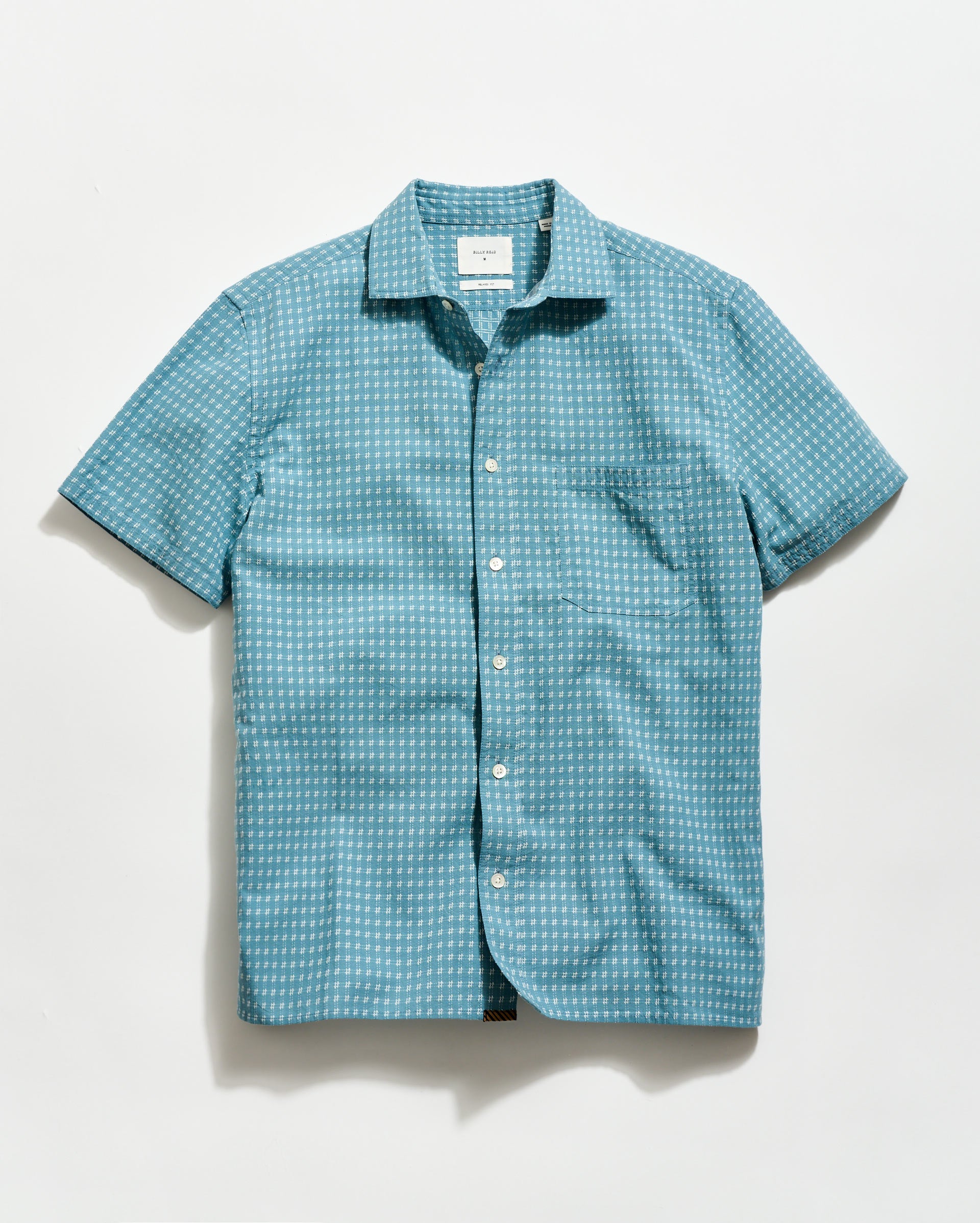 Blue patterned short-sleeve shirt on a light gray background