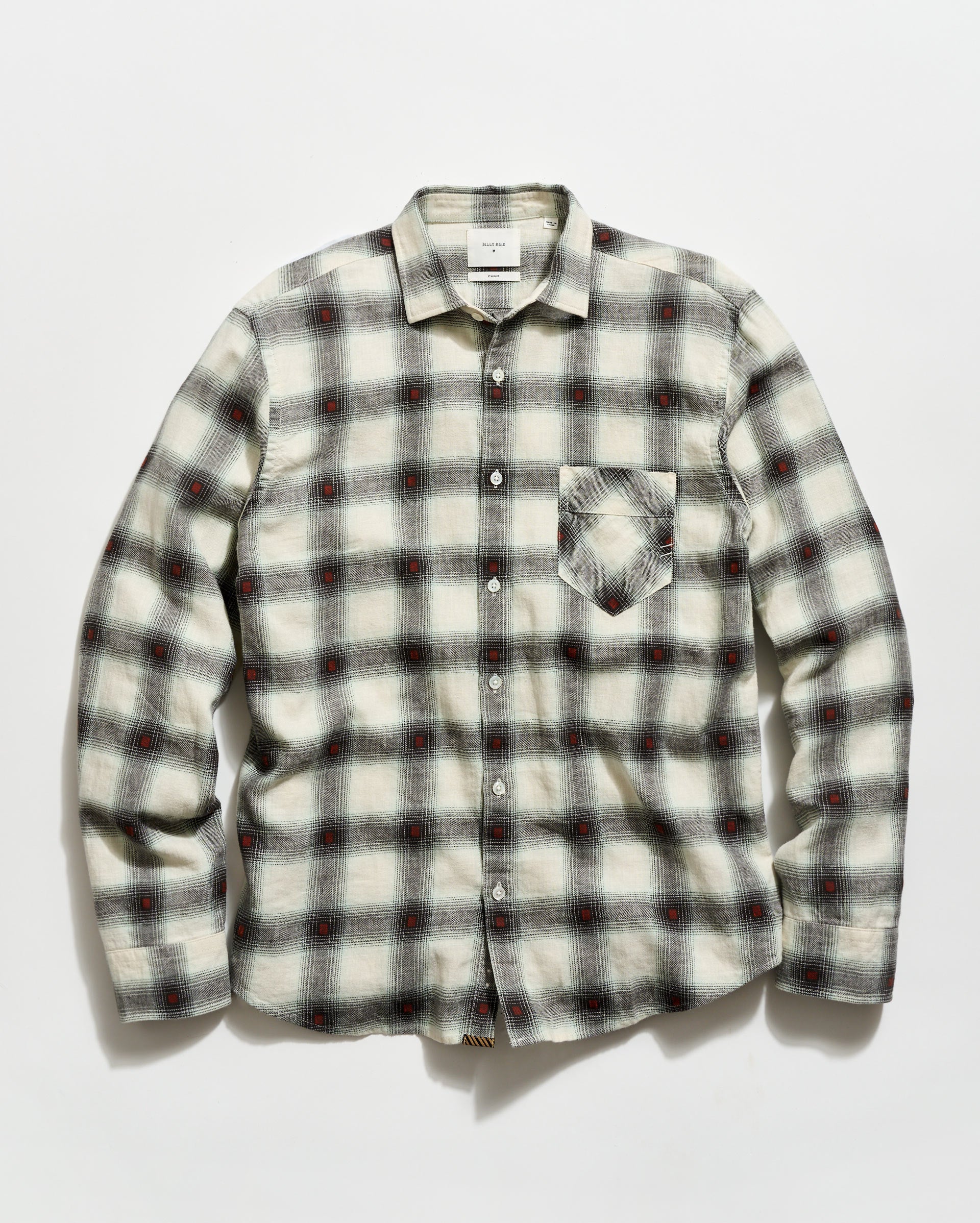 Plaid shirt with a pattern of black, red, and white on a light gray background