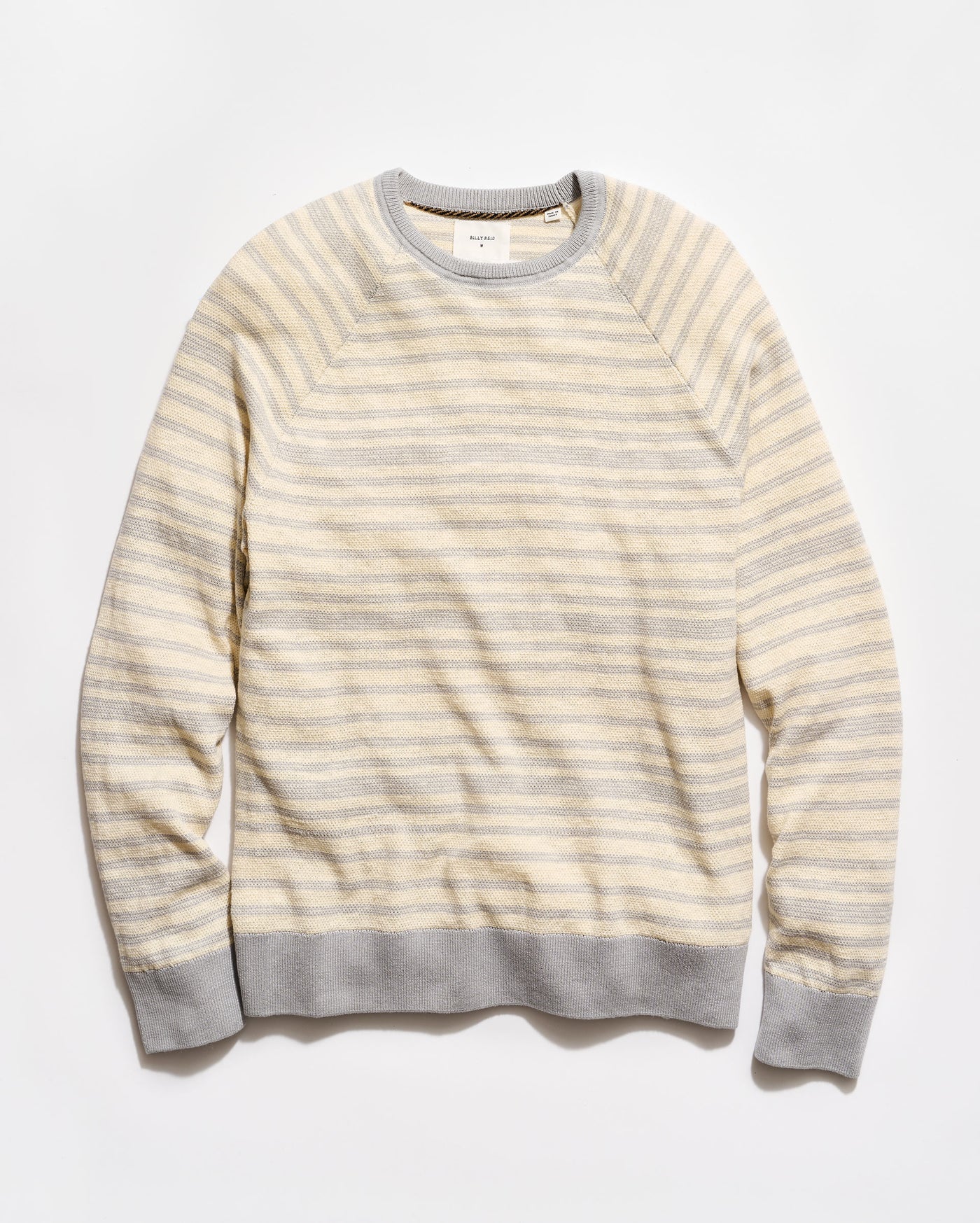 Striped sweater with a light yellow and gray pattern on a white background