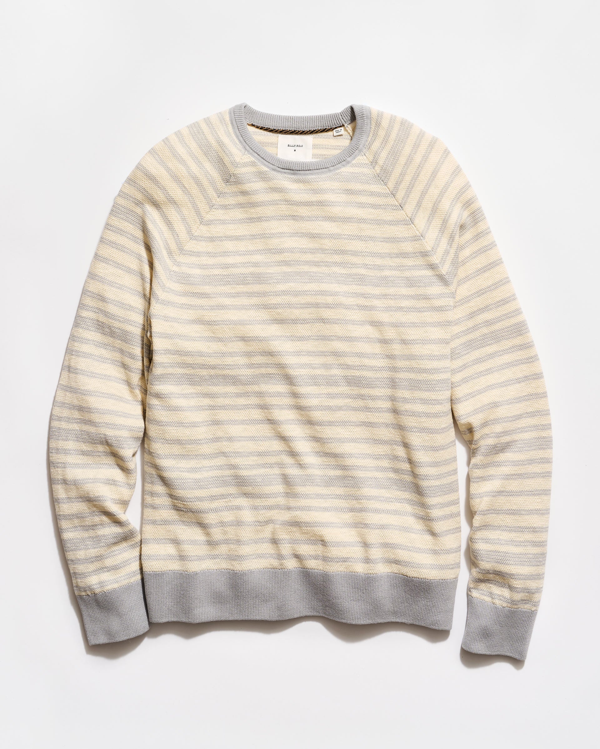 Striped sweater with a light yellow and gray pattern on a white background