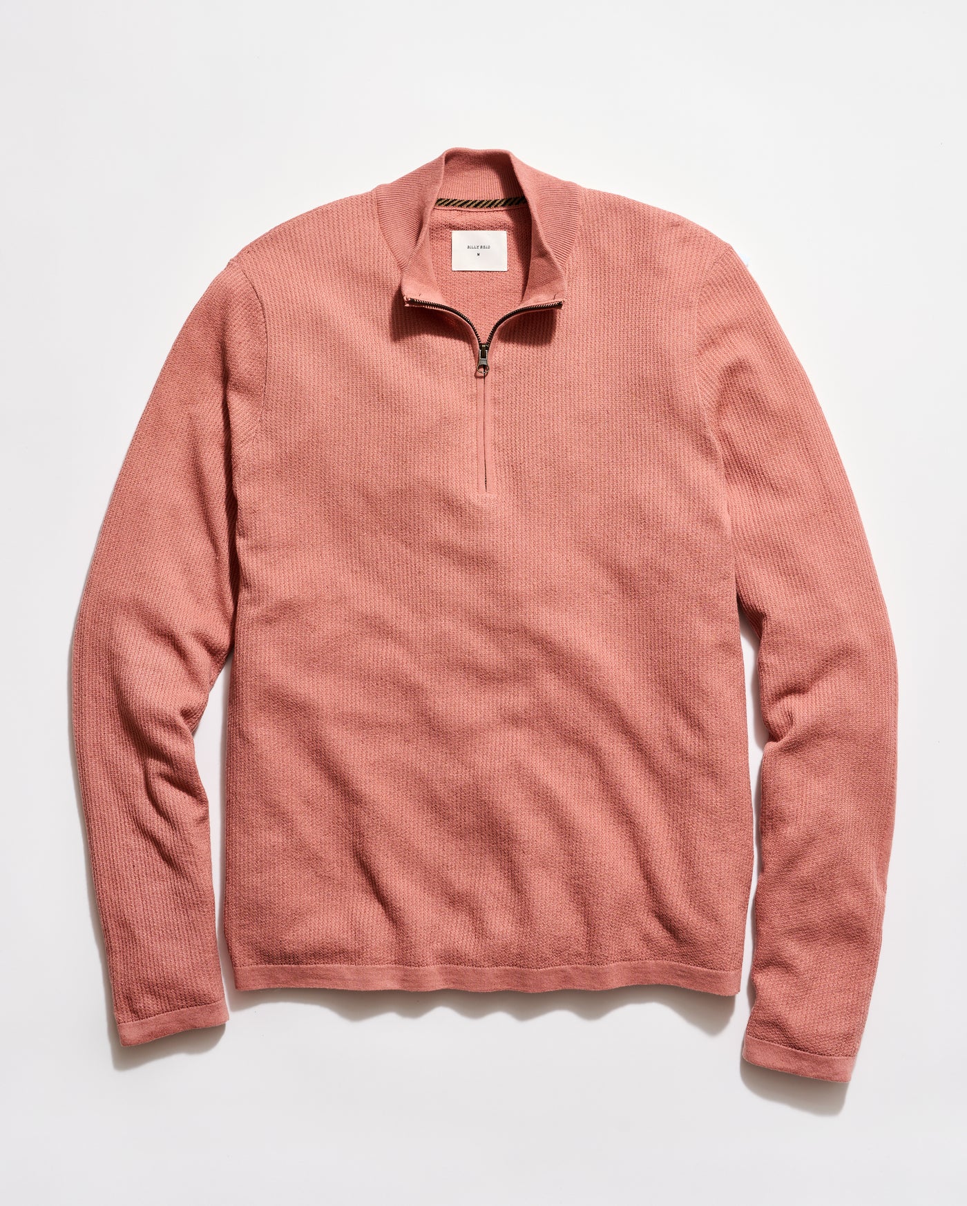 Pink long-sleeve shirt with a quarter zip on a white background