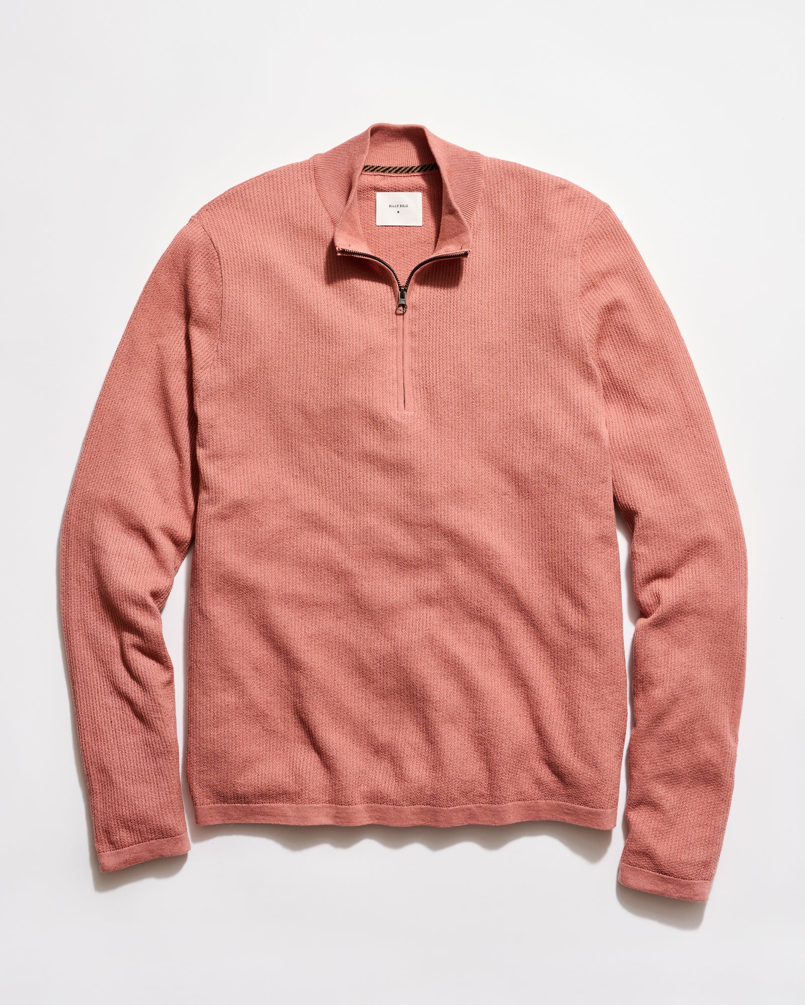 Pink long-sleeve shirt with a quarter zip on a white background