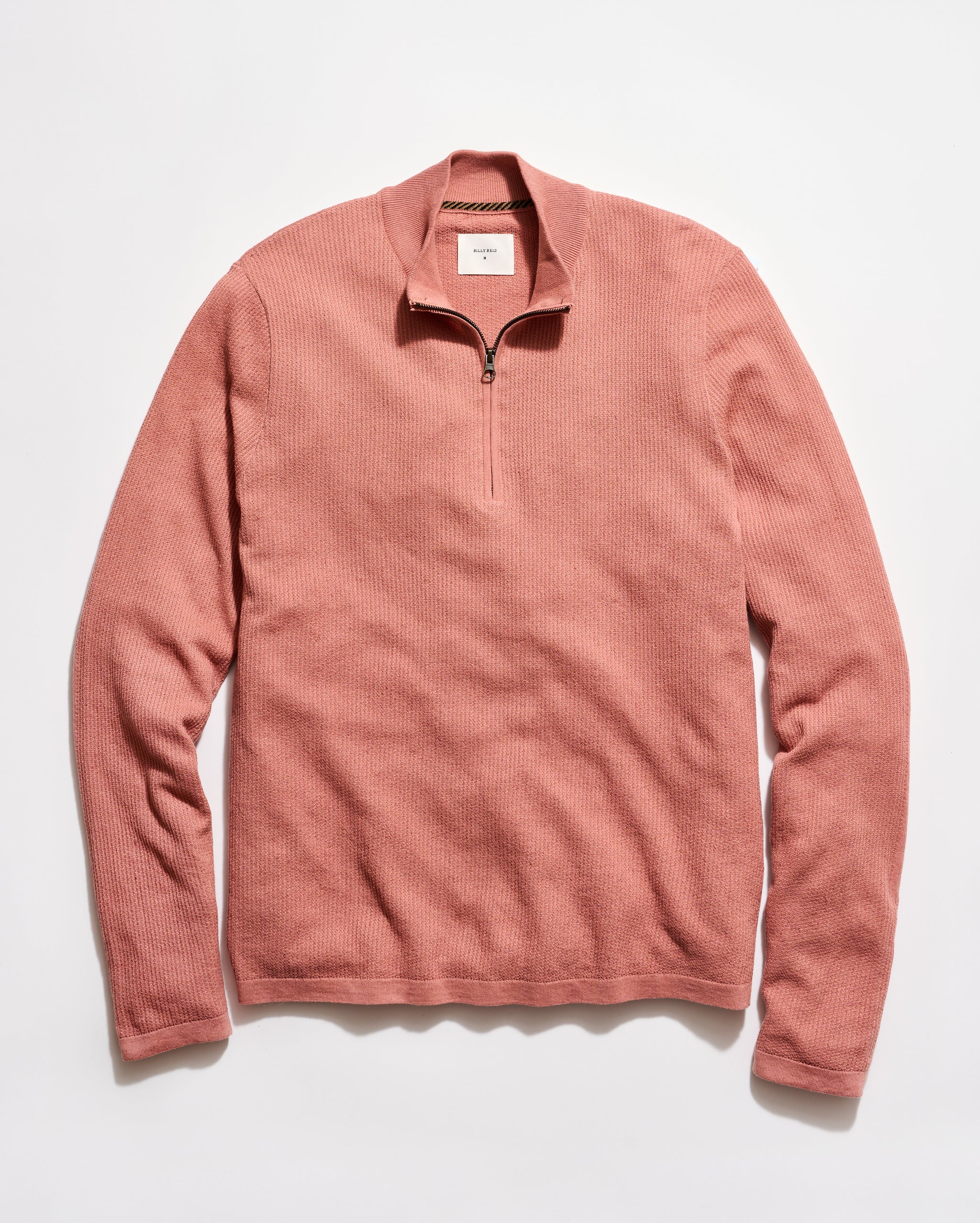 Pink long-sleeve shirt with a quarter zip on a white background