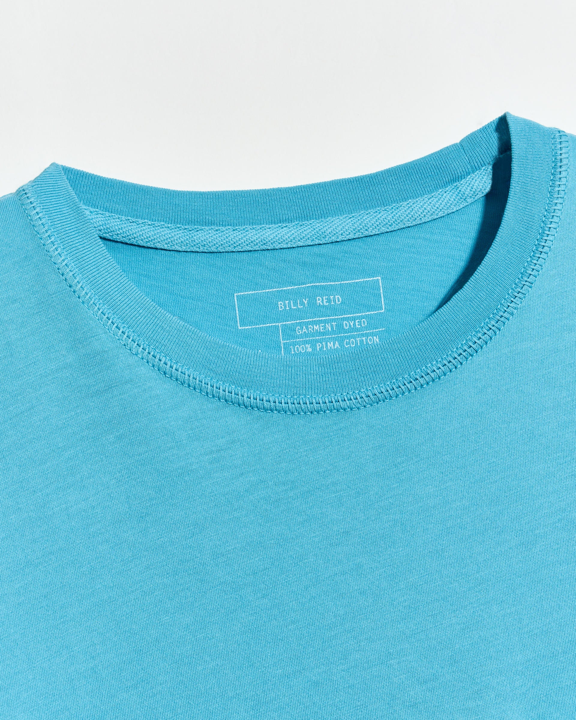Close-up of a blue t-shirt with a brand label on the collar.