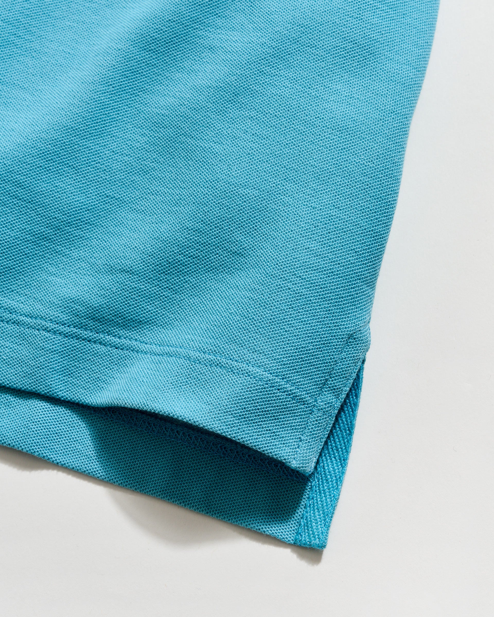 Close-up of a blue fabric edge on a light gray background