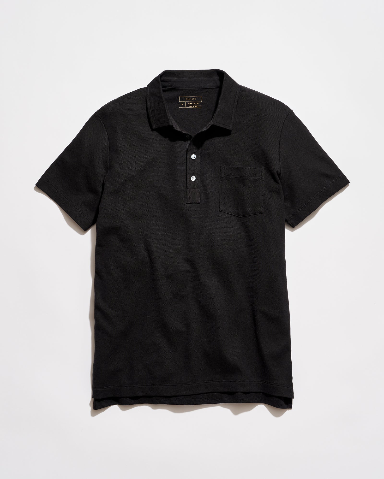 Black polo shirt on a light gray background