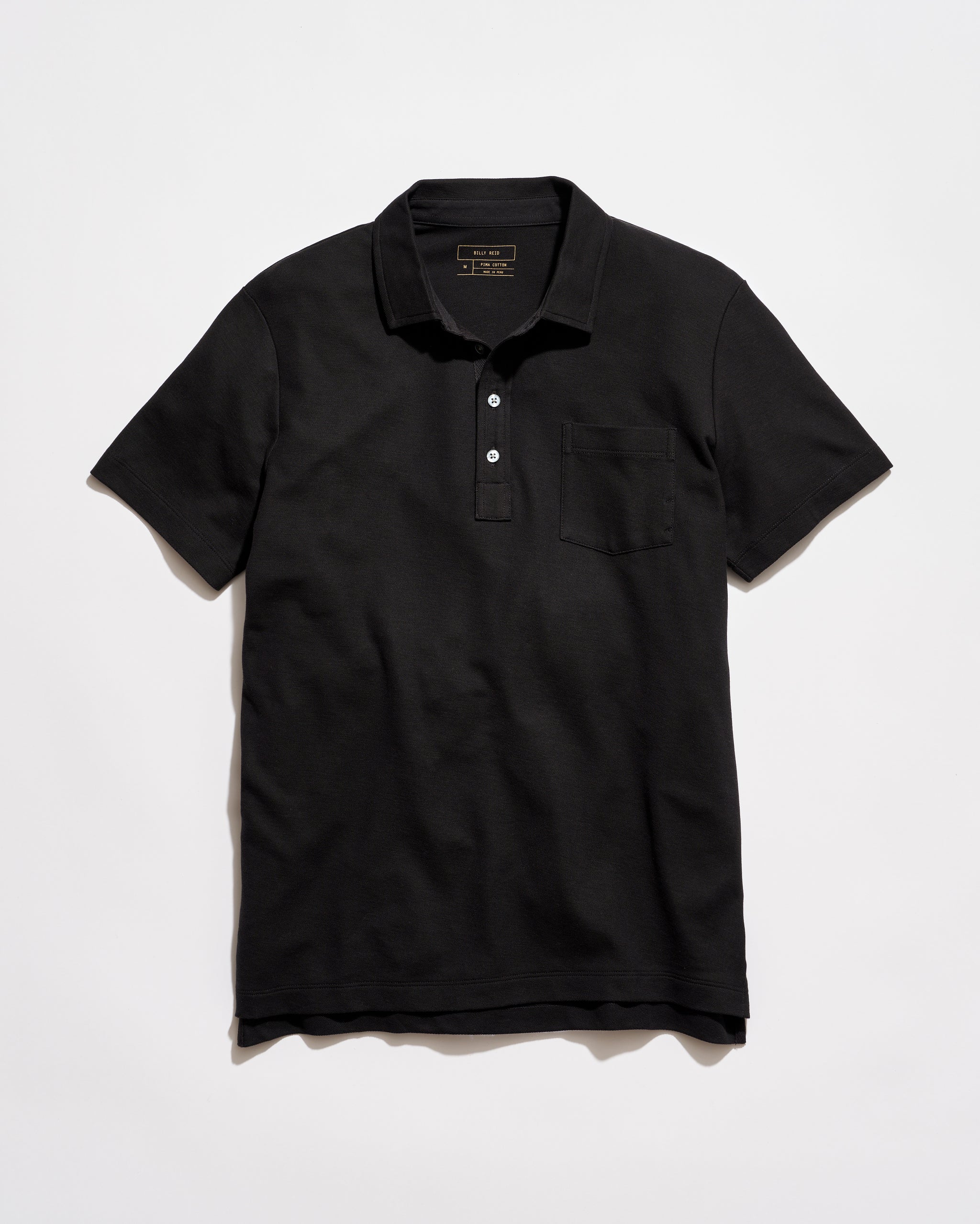 Black polo shirt on a light gray background