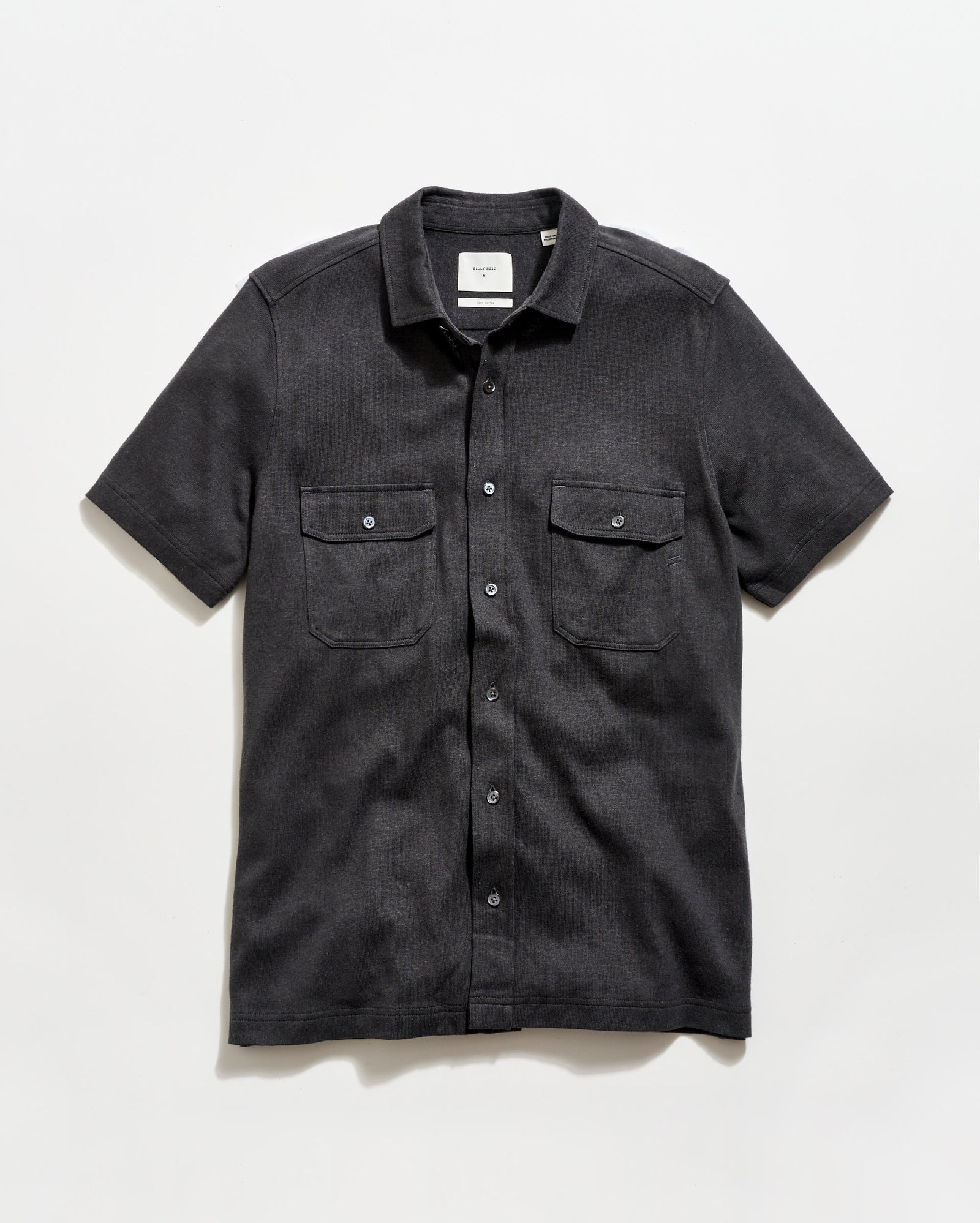 Black short-sleeve shirt with two pockets on a white background