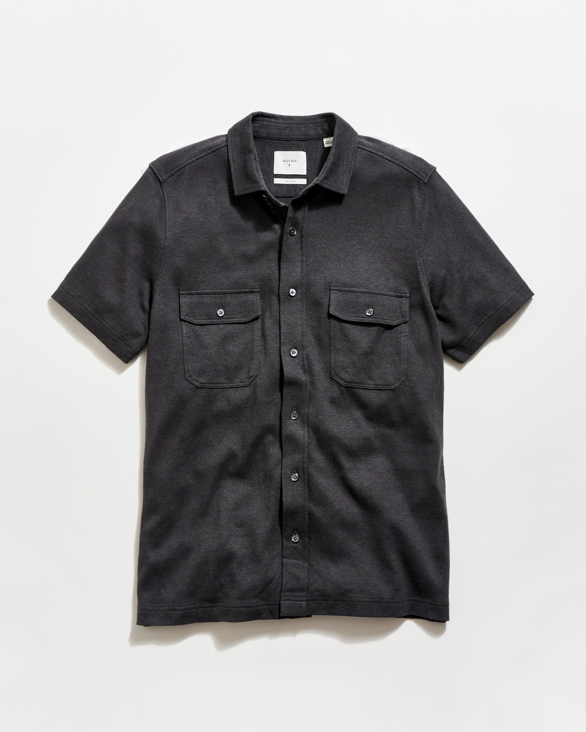 Black short-sleeve shirt with two pockets on a white background