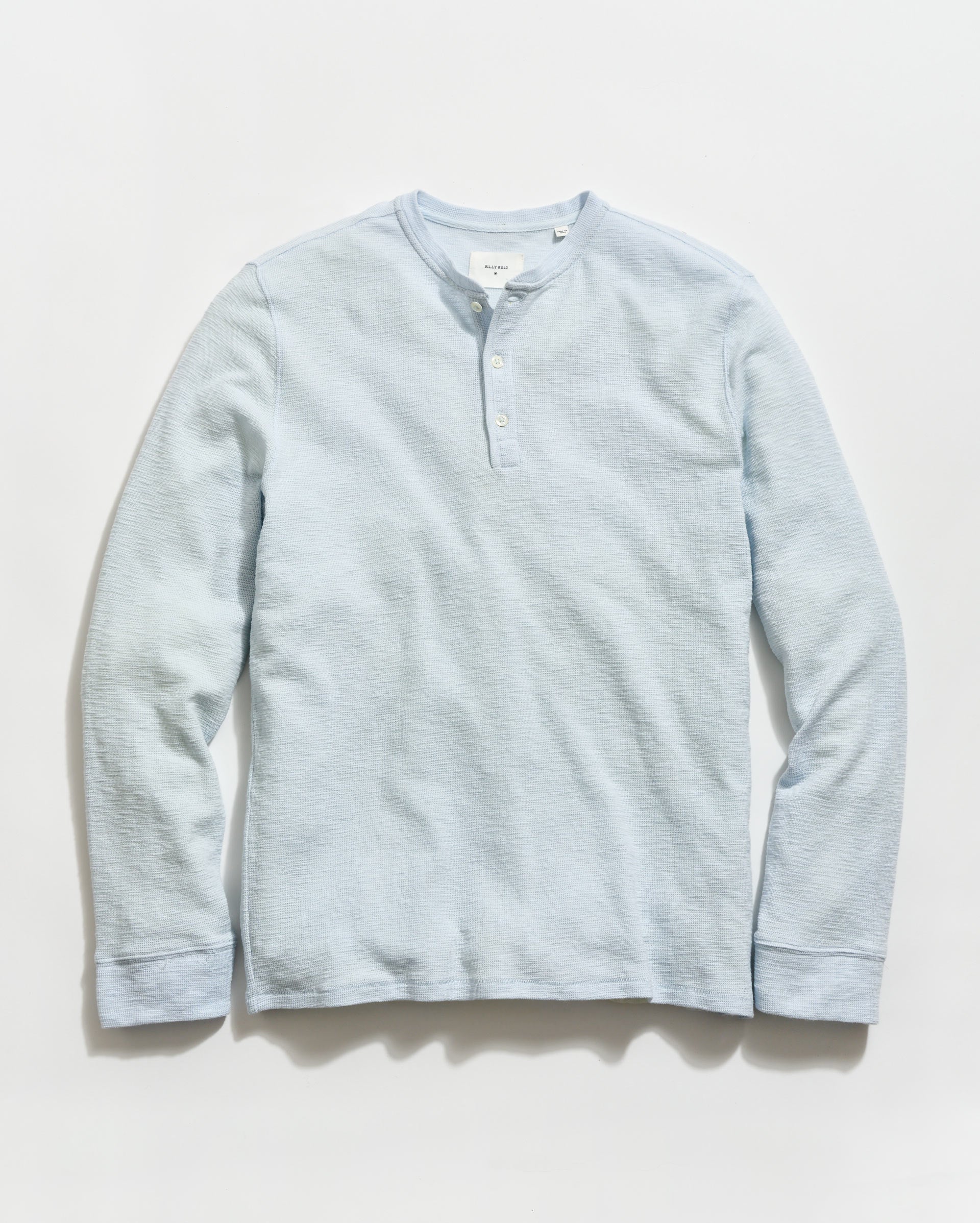 Light blue long-sleeve shirt on a light gray background